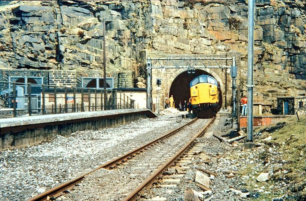 WoodheadRoute's tweet photo. 40 years ago today 

4th May 1986, and loco 37024 emerges from the "new" Woodhead tunnel for the very last time as track lifting had reached the tunnel entrance.

© Normand1946 https://t.co/fdrDPEPOjc