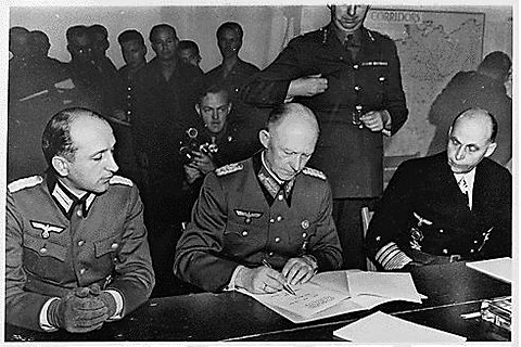 MilHistNow's tweet photo. RIGHT NOW in 1945, Generaloberst Alfred Jodl marches into Eisenhower's Reims, France headquarters and signs the German Instrument of Surrender. A UPI reporter describes the mood as "cold military punctiliousness." Stalin demands a second surrender take place in Berlin on May 8. https://t.co/e9XNXjvuXY