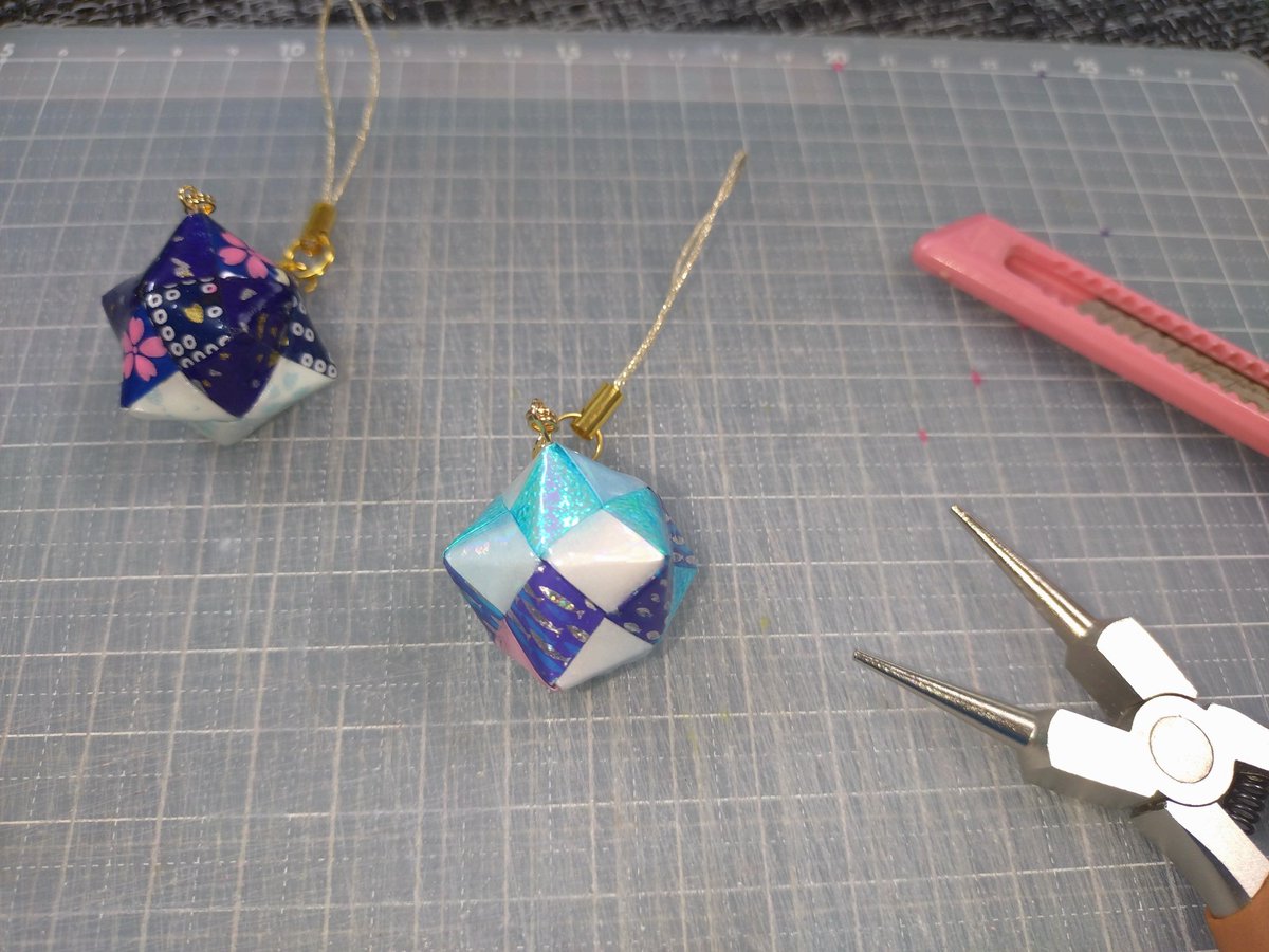 44061's tweet photo. 折り紙で作る極小のくす玉ストラップ

今年の夏も暑くなるんでしょうか？

季節を先取り、
青を基調にして魚柄をあしらった
夏っぽい海っぽいくす玉を作ってみました。

気温が上がっても、
気分だけは涼しく過ごしていきたいですね。

#折り紙 #origami #くす玉 https://t.co/ziH8BkWc2q
