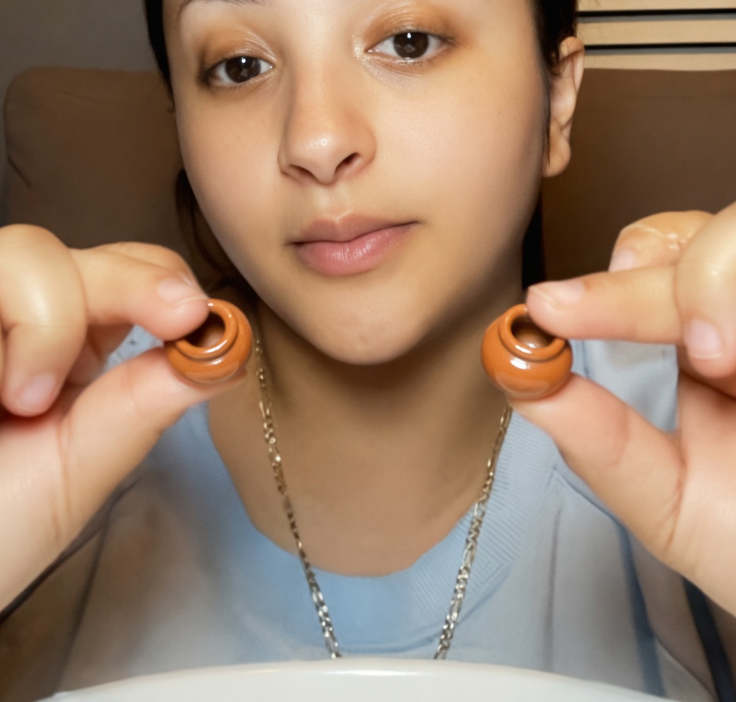 This is the viral "eating mini clay pots" trend on TikTok.
People take small terracotta clay pots (just like the orange pitcher), fill them with lime or lemon juice, cover them with Tajín seasoning (chili-lime mix), and eat the whole pot in one go.
The pots make a loud crunchy