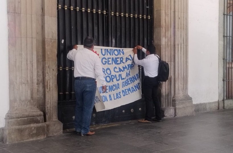 CuartaPlana's tweet photo. #Entérate | Integrantes de la #UGOCP protestan en Palacio de Gobierno de #Oaxaca. Piden audiencia con el gobernador @salomonj para que atienda necesidades, pero denuncian que @KarinaBaronO los bloquea desde la @SESESP_GobOax.
#Noticias #BuenosDías @GobOax @jesusromerooax
https://t.co/bBLwKUXBUW