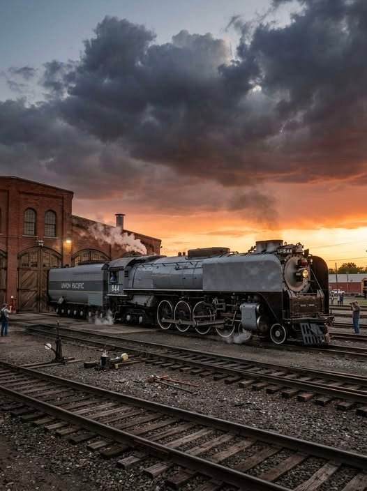 JonRodg97335205's tweet photo. The  legendary 4-8-4 Northern-type stands proud, its polished rods and  classic lines glowing under fading light while crews prepare for the  next run—pure railroading nostalgia in motion. https://t.co/sw4Px6HRim