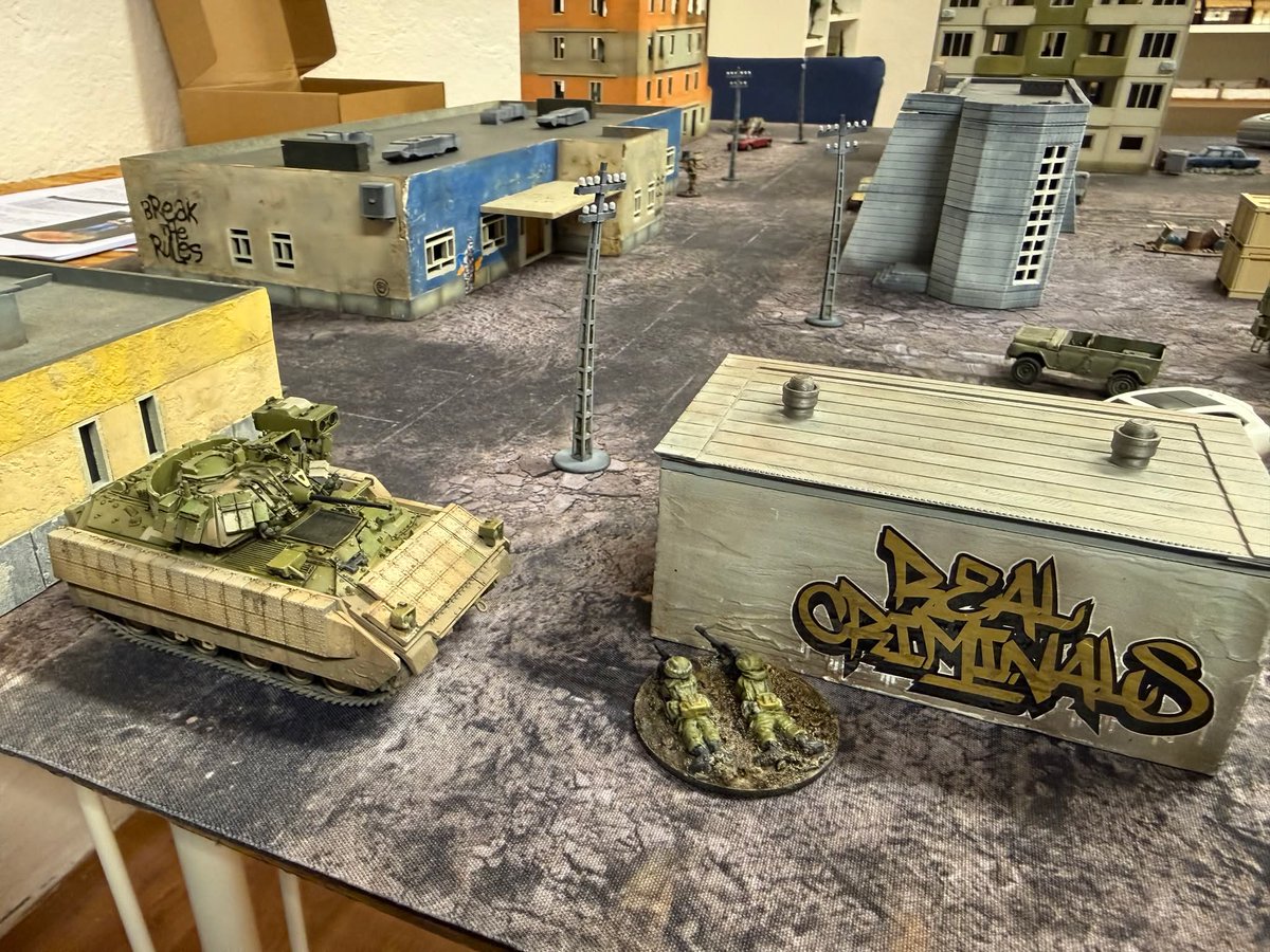 PotanCZ's tweet photo. 2/3 🧵 Wargaming in Czechia - Stunning 22mm modern game using What a cowboy/cartel rules in Prague Wargames Club. 🔥 If you're from Czechia and want to join the community, feel free to DM/comment and I will navigate you to the Czech historical wargaming group. 😉 Pics from Andreas. 📷

Also, small AAR from Andreas: We tried "What a Cartel" by Too Fat Lardies. It’s a modern-day variation on "What a Cowboy." The game is just as fun as the cowboy version, but the Ukraine theme doesn’t really fit. It’s more geared toward individual "soldiers"—that is, battles between drug cartels and the police and similar shenanigans. For the Ukrainian battlefield, we’ll stick with INX, which fits better, but we liked the rules for how vehicles and tanks are handled (basically very similar to CoC), and since INX’s tanks are pretty half-baked, we’ll run it using these rules.

The scenario itself was about heroic Ukrainians freeing DHL employees from Russian clutches, which they succeeded in doing. Although a Russian T-80 arrived and managed to destroy a Ukrainian Bradley, the DHL employees managed to escape into a parked red Charger.