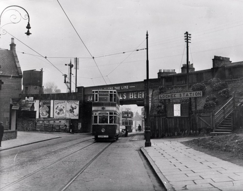 DundeeArchives's tweet image. Lochee Tram coming into Lochee, and another in distance heading back into town. Lochee Station sign visible on right. The bridge was removed in the 1970s. 

Date: c.1950s 

Reference: GD/MUS230/14/2/7 

#TransportTuesday #Dundee #Archives