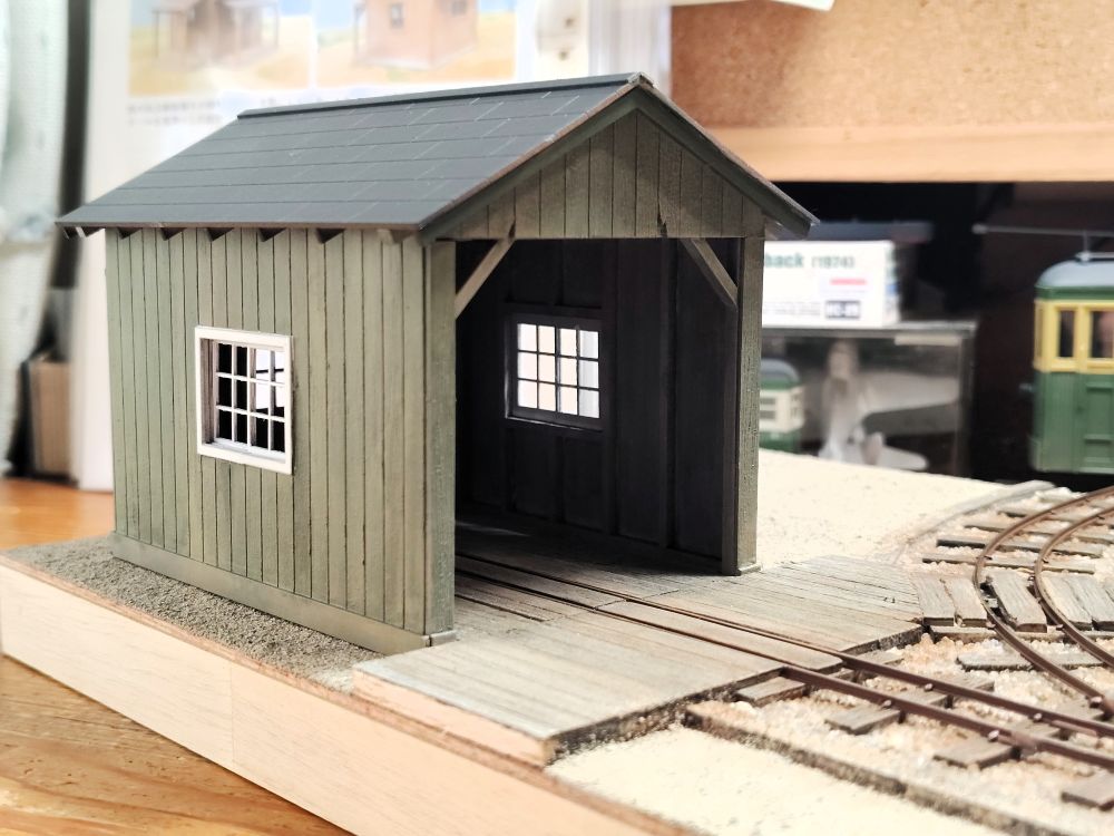 sakurayamalr's tweet photo. On18（1/48・9mm）のモジュール製作。
地面は砕いた砂岩を撒いたもの。枕木の塗装は薄めたフラットブラックをベースに、ブラウン系を少しずつ重ねてゆきます。車庫の壁はくすんだグリーン（フィールドグレイ）にしました。
この連休中の工作は、ここまで。 https://t.co/QSQMPpJ9iU