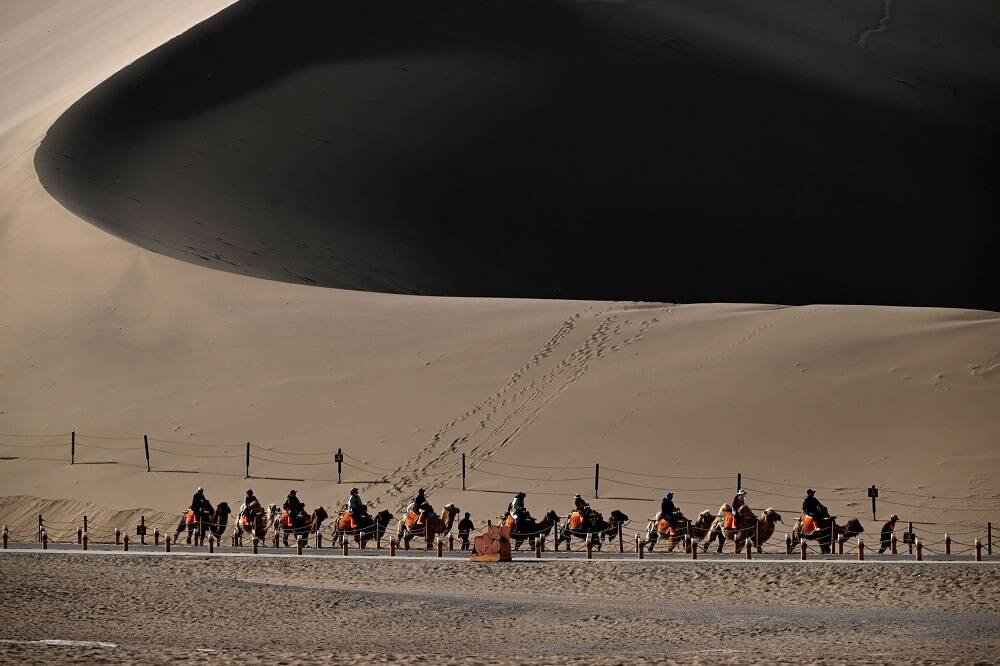 wheels_china's tweet photo. Tourists visit Mingsha Mountain and #CrescentSpring Scenic Area in #Dunhuang, Gansu province.
#敦煌鸣沙山月牙泉景区驼队铃声阵阵。 https://t.co/tavPcpksWN