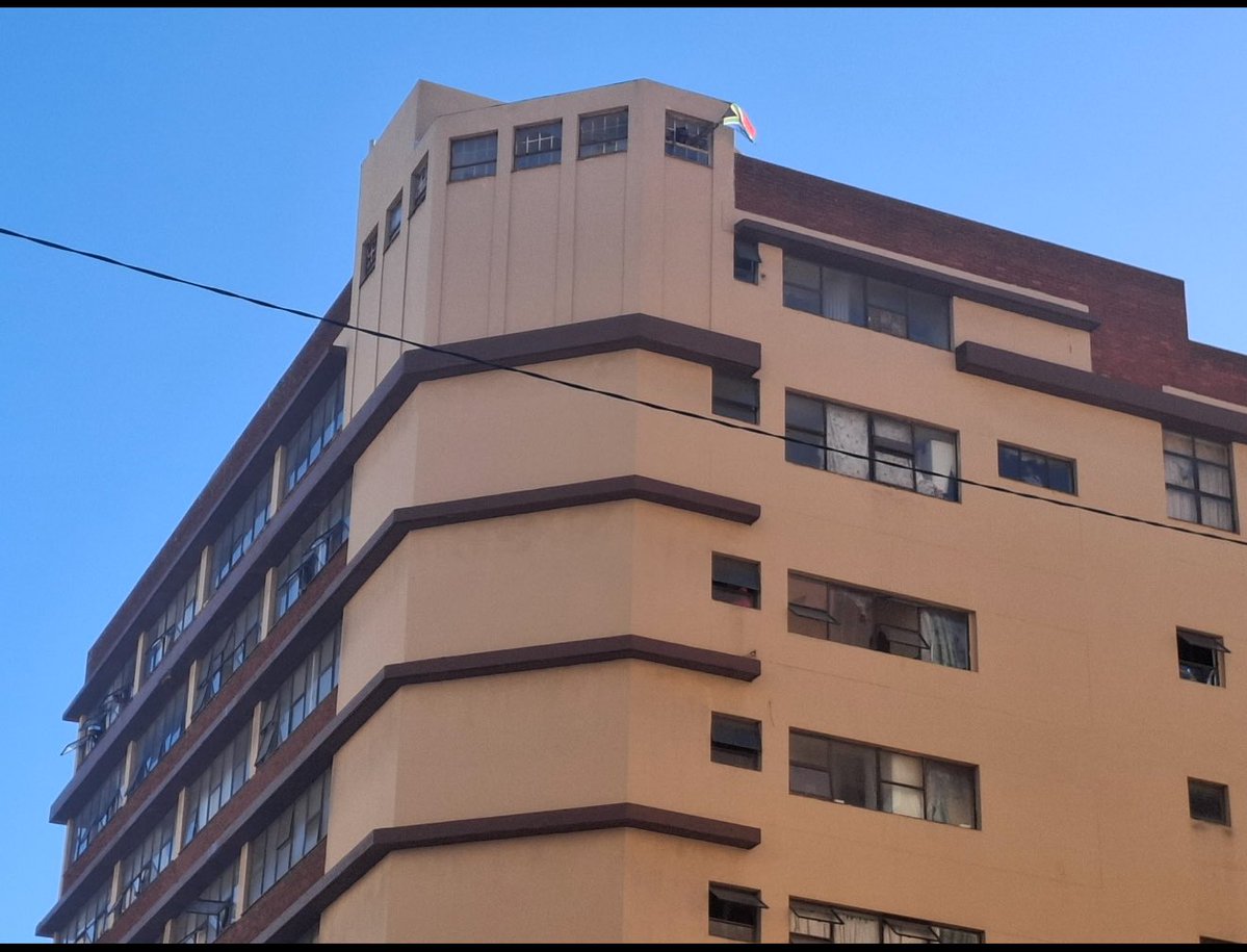Ngizwe Mchunu raising a South African flag on the last floor of the flat after Xolani Khumalo caught drug dealers inside✊🏾