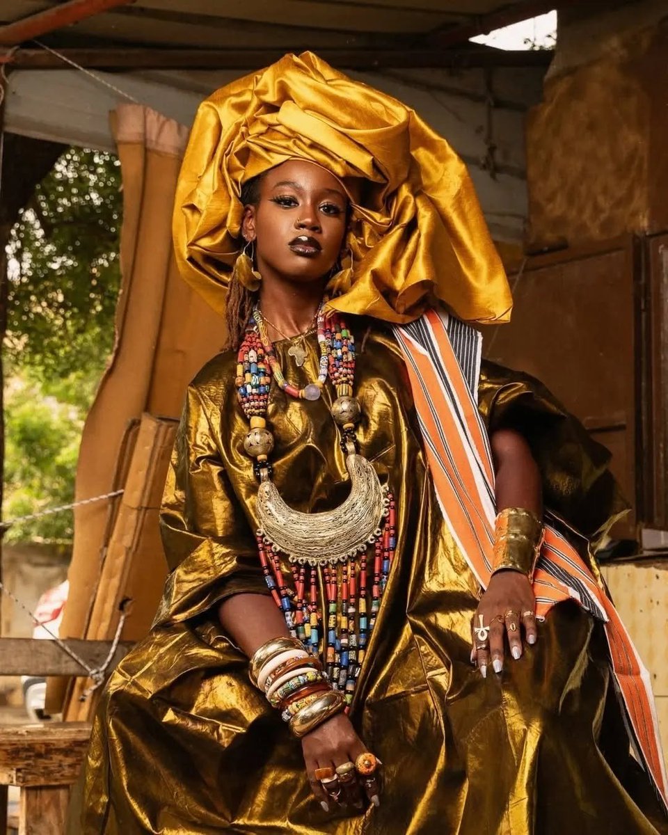 Gold on her skin, history in her hands. Can you guess the African country?