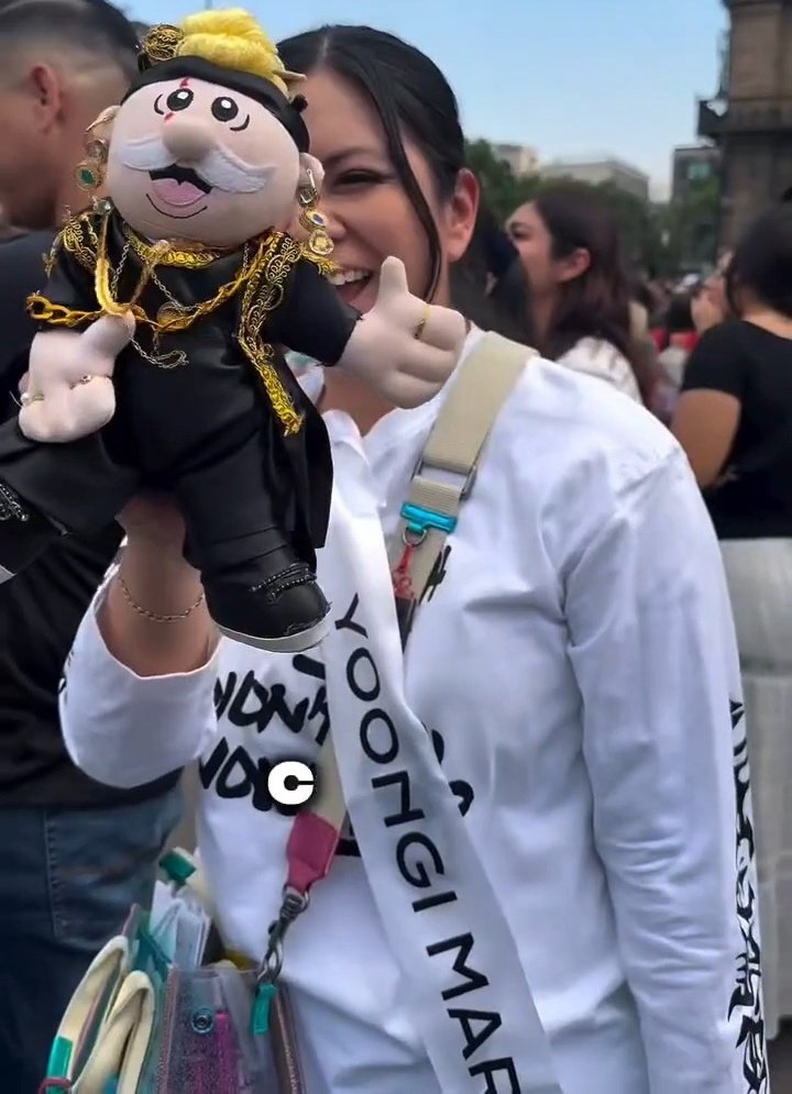 DataAgustD's tweet photo. An ARMY brought a customized Dr. Simi plush dressed as Daechwita Yoongi to the National Palace 🇲🇽🥹

Dr. Simi is an iconic mascot in Mexico, popularized by Farmacias Similares, a Mexican pharmacy chain. Fans often dress these plush dolls in themed outfits and gift them to artists. It has become such a fun concert tradition there