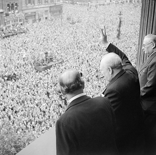 DrHelenFry's tweet photo. Winston Churchill stood on the balcony in Whitehall on 8 May 1945, waving triumphantly to the vast cheering crowds below and raising his famous V for Victory salute.

It became the unmistakable symbol that the long, bitter war in Europe was finally over. https://t.co/9BZhyAwcs4