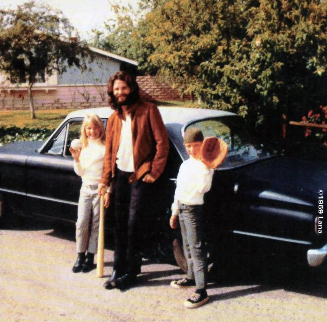 GumbootRecords's tweet photo. In May 1969, Jim Morrison was photographed with a woman known only as “Lana” at her family’s home in Granada Hills, where the leather-clad poet kicked around a baseball with her younger siblings before settling in for an evening of fondue. https://t.co/7plJny3w6I