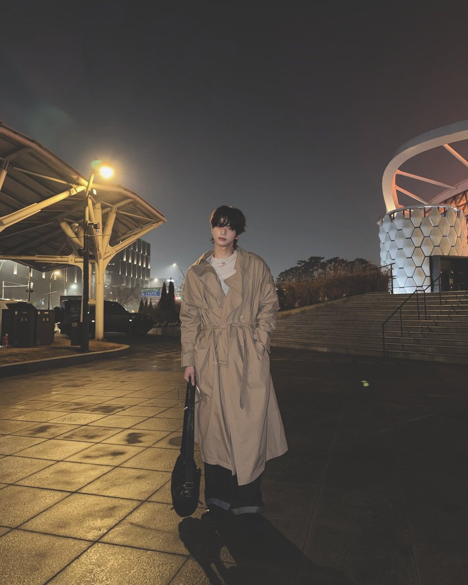 bshinyu's tweet photo. The city lights blurred softly behind me as I stood there in the quiet chill of the night, my trench coat wrapped around me like an old friend. The air felt heavy with unspoken thoughts, and for a moment everything else faded—the distant hum of the streets. https://t.co/rq9xCZugFG