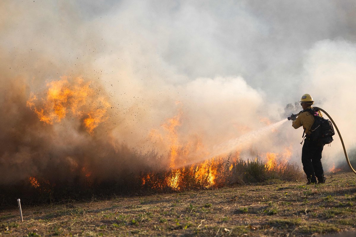 ChinaDaily's tweet photo. Crew members combat the #SandyFire as it continues to burn in the hills near a residential area in Southern #California, on Wednesday. The wind-driven brush fire broke out on Monday in Simi Valley, a city of around 125,000 residents about 48 kilometers northwest of Los Angeles, spreading rapidly and prompting authorities to issue evacuation orders for thousands of people. #fire #US