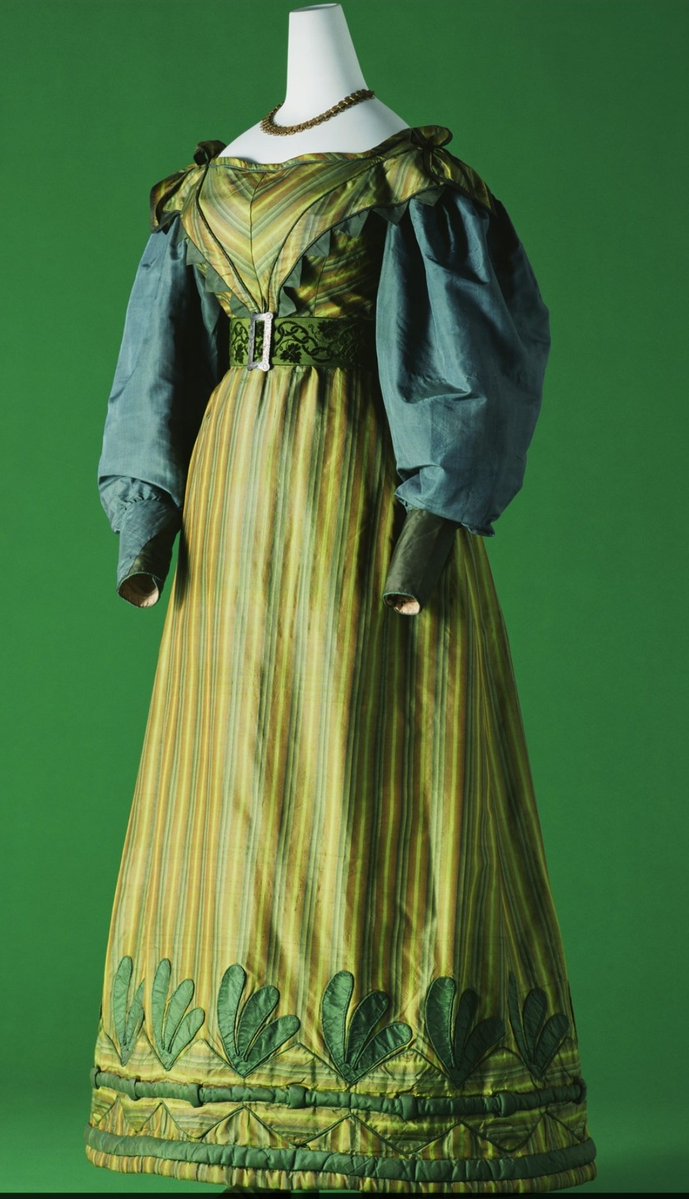 England Day dress, c.1826 Green and yellow striped printed silk taffeta; green silk taffeta large sleeves; leaf-shaped appliqus with projecting edge at hem of skirt; bows at top of shoulder. Kyoto Costume England Day dress, c.1826 Green and yellow striped printed silk taffeta; green silk taffeta large sleeves; leaf-shaped appliqus with projecting edge at hem of skirt; bows at top of shoulder. Kyoto Costume