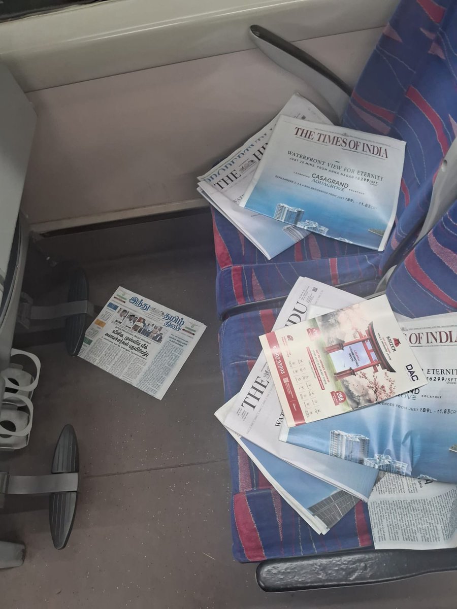 707Stewart's tweet photo. What is the need for dumping newspapers like this in Vande Bharat 20607? A few copies could be kept in a common space for passengers who read to pick up. This is an utter waste of public money, and it's scattered all over for us to clean. @RailMinIndia @RailwaySeva @IRCTCofficial https://t.co/NPqPGNrrX1