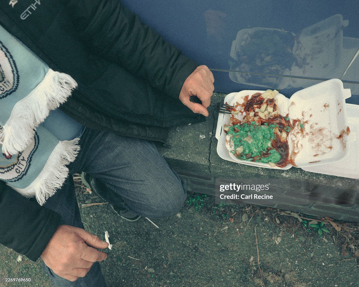 shitbritishpics's tweet photo. A Manchester City fan eats Chips, peas and gravy outside the Etihad Stadium prior to the Emirates FA Cup Quarter Final match between Manchester City and Liverpool (2026) https://t.co/ydmHHm7ENx