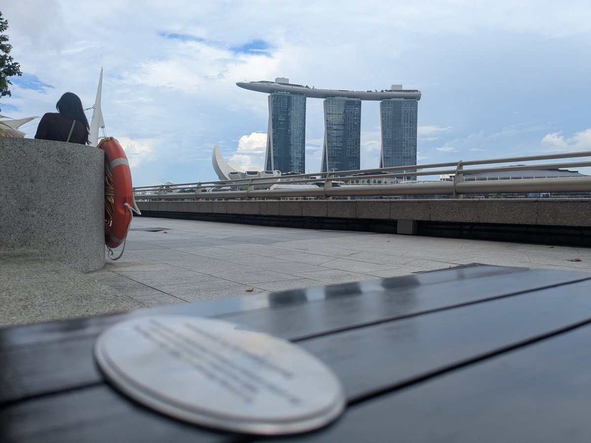 SoferoLiu's tweet photo. #于朦胧 #YuMenglong #YuMenglong于朦胧 #JusticeforYuMenglong 12 May 2026 never forget never forgive, at the memorial bench in Singapore at esplanade bayfront, with Alan singing in the background 🐟8 months since, and we will be here waiting for the day justice is served. https://t.co/jJhYpKXOKZ
