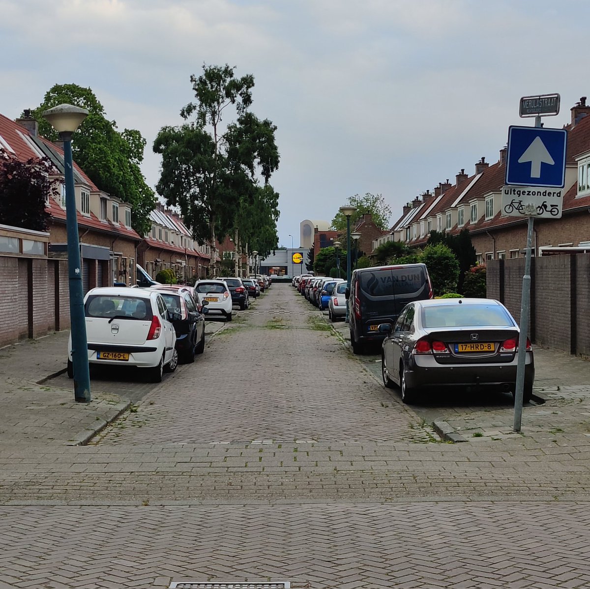 onzecis's tweet photo. Onkruid dat langzaam wint van de straat, de LED-bak van de Lidl die het wint van de schemering en als kers op de taart een betonmortelcentrale op de achtergrond. 
Soms word je onverwacht getrakteerd op een mooi plaatje. @JScheurbuijck https://t.co/IRaCI0wUHy