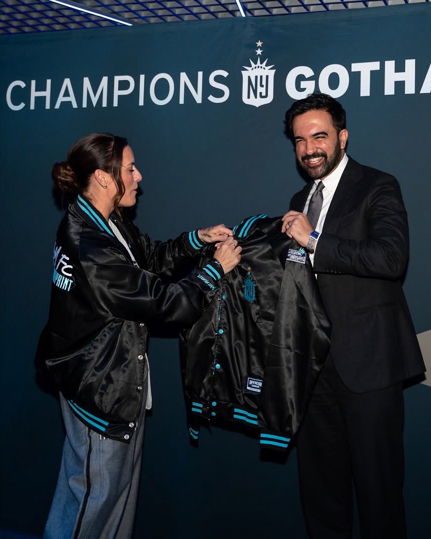 officialeague's tweet photo. NYC Mayor Zohran Mamdani sporting our latest collaboration with Gotham FC, The Blueprint Satin Jacket. 

2x World Cup champion Ali Krieger joined WNBA legend Sue Bird to present the mayor with his own custom Blueprint satin. https://t.co/0QfOddzLPT