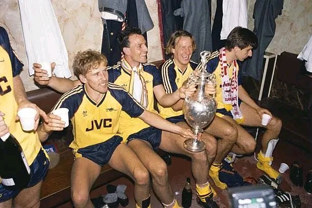 AnythingArs_'s tweet photo. When Lee Dixon won the league with Arsenal at Anfield in 1989, he did not go back to London with the rest of the players.

That became one of his biggest regrets.

Arsenal had just beaten Liverpool 2-0 on the final night of the season.

They needed to win by two.

Michael Thomas got the second in the final moments and Arsenal had won the title at Anfield.

The whole squad were going back to London to celebrate.

Dixon had already made other plans.

His uncle was over from Australia, his mum was having a party, and he had told her he would go because he did not really think Arsenal were going to win anyway.

So while the rest of the players were leaving together, Dixon was stood outside Anfield with his championship bottle of champagne, waving them off.

The lads were looking at him like he had lost his mind.

“What are you doing?”

“I don’t know.”

So instead of going back to London for one of the biggest celebrations in Arsenal’s history, he got in the car with his brother and headed to his mum and dad’s.

He still had his Arsenal blazer on.

He had already had some champagne.

And somewhere in Liverpool, he realised he was starving.

They had not eaten properly since about three o’clock.

His brother spotted a chip shop.

“There’s a chippy there.”

There were four of them in the car, so Dixon asked what everyone wanted.

Then he got out and went in himself.

He did not think about where he was.

He did not think about the Arsenal badge sitting on his chest in the middle of Liverpool, on the day Arsenal had just won the league at Anfield.

Then he opened the door.

The place was packed.

That was when he looked down and saw the badge.

“Oh my God.”

“This is the end of it.”

He could hear all the voices around him and just tried to get the order in.

“Four fish and chips, please.”

The bloke behind the counter looked at him.

Then he looked at the Arsenal badge.

And instead of anything kicking off, he just said:

“It’s alright, lad.”

“You can have extra chips.”

“We’re all Evertonians!”

So Lee Dixon missed the Arsenal party in London.

But he still ended up celebrating the title in a Liverpool chip shop with a room full of Everton fans.
