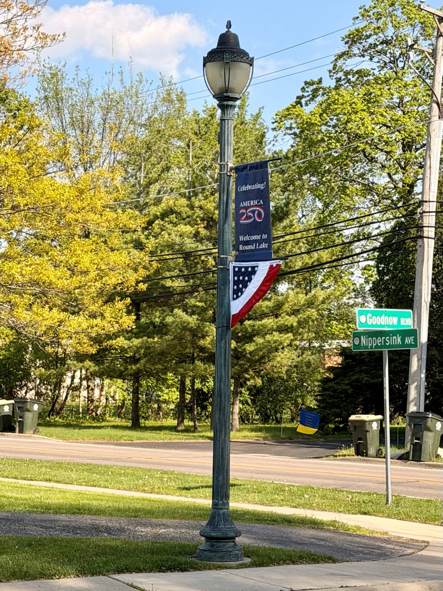 roundlakeil's tweet photo. The Village recently installed new America250 banners as we begin recognizing and celebrating the upcoming 250th anniversary of the United States in 2026.
These banners are a great addition to our downtown. 
Be sure to check them out next time you’re downtown! https://t.co/hrJog7EUZG