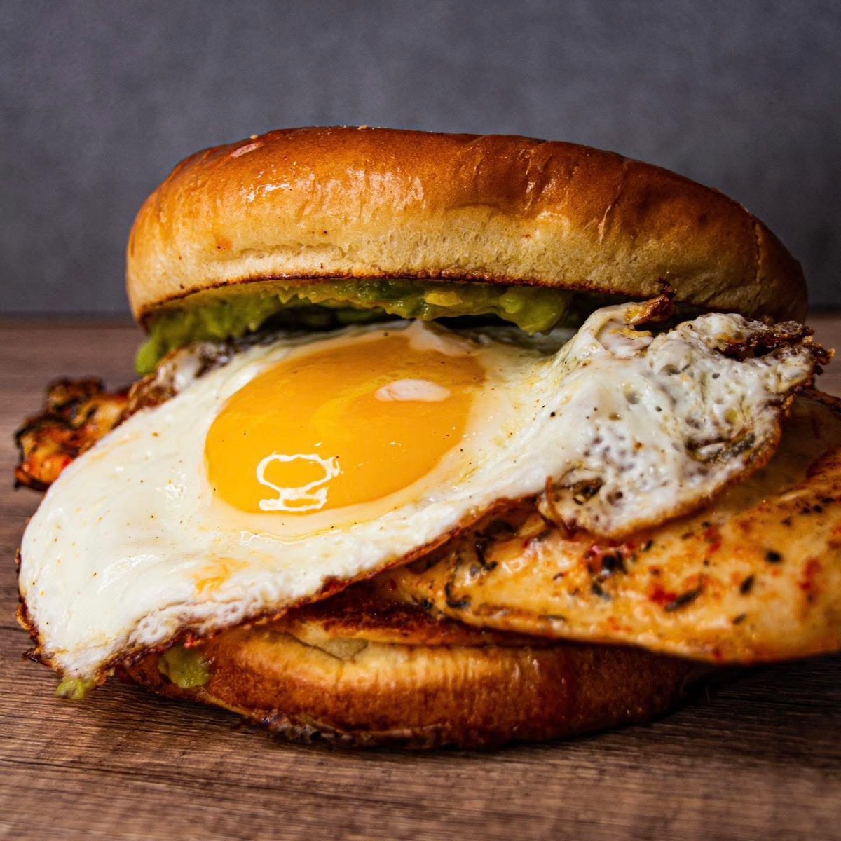 dccobbs's tweet photo. Meet Smilin Dan at D.C. Cobb's - Grilled chicken breast tossed in buffalo sauce, stacked with bacon, pepper jack cheese, a fried egg, guacamole, and pickled jalapeños on a roasted brioche bun. Big flavor in every bite 🔥🍔 https://t.co/bExAzyqtzG