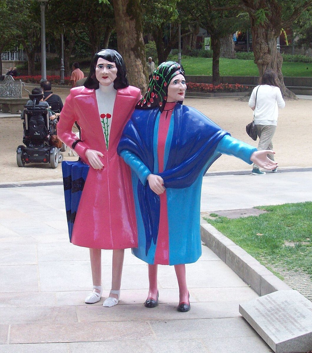 outsidersesp's tweet photo. Las Marías: el franquismo reprimió a estas hermanas en Santiago y ellas respondieron con vestidos chillones.

Maruxa y Coralia Fandiño sufrieron la represión franquista debido a que sus hermanos militaban en la CNT cuando estalló la Guerra Civil.

En Santiago de Compostela hay un símbolo laico, republicano y feminista que cada vez acapara más visitas. En el parque de la Alameda, en pleno centro, un grupo de visitantes se amontonan frente a dos coloridas estatuas que resaltan frente a la piedra y los símbolos religiosos que caracterizan a la ciudad. Se trata de la escultura de dos mujeres vestidas de amarillo y rosa que simulan caminar agarradas. Son las conocidas como las dos Marías.

Tras la imagen de las figuras se esconde una dura historia de represión política y exclusión social que gran parte de los turistas desconocen. Estas dos mujeres son Maruxa (1898-1980) y Coralia (1914-1983), hermanas pertenecientes a la familia Fandiño Ricart.

Rondaba el año 1932 y el clima de progreso y alegría envolvía la capital gallega. «La llegada de la República trajo una democratización de la vida cotidiana y un avance de libertades a las mujeres que se estaba empezando a conseguir», relata la historiadora Encarna Otero.

Las dos inseparables hermanas trabajaban en el taller de costura de su madre y tenían una costumbre que cumplían cada día: salir de su casa a las 12 de la mañana para recorrer, siempre juntas y cogidas del brazo, las calles de Santiago. Un paseo que terminaba a las dos del mediodía, hora en la que las señoras de la época se recogían, de ahí que también fueran apodadas como «As dúas en punto (las dos en punto)».

Todo cambiaría con la llegada de la Guerra Civil en 1936. En Galicia, aunque no llegó a estallar el conflicto bélico, se produjo un exterminio y persecución contra aquellas personas militantes de izquierdas y fieles a la República. En el período de guerra, fueron ejecutados unos 4.700 gallegos por motivos políticos y más de 28.000 sufrieron persecución policial.

Maruxa y Coralia vivieron de primera mano la represión franquista. Sus hermanos, Antonio, Alfonso y Manuel, eran sindicalistas de la CNT, por lo que ellos tuvieron que huir de Galicia o esconderse. Mientras tanto, la Policía franquista se presentaba en la casa familiar y amenazaba a las dos hermanas para que revelaran dónde se encontraban. Ante la negativa, comenzarían las vejaciones, torturas y abusos contra ellas. Fueron constantemente humilladas por la Policía del régimen en público, convirtiendo su vida en un infierno.

Las mujeres de la casa tuvieron que vivir las amenazas y controles de los falangistas a cualquier hora del día, siendo víctimas de una represión indirecta debido a la búsqueda de sus hermanos en el hogar familiar. «Las mujeres van a ser las primeras que estén sobre el control férreo de la Sagrada Cruzada; el control de la Iglesia fue terrorífico y en Santiago fue aún peor».

Ellas nunca revelaron dónde estaban sus hermanos, a pesar del constante acoso. La tortura no terminó incluso cuando años más tarde aparecieron todos ellos. Fueron señaladas como rojas, putas y locas. «Ya nadie acudía a su negocio, perdieron la clientela en el taller de costura, de forma que se quedaron sin empleo, su medio de sustento y supervivencia». Desde entonces, el hambre estaba presente en el día a día de sus vidas, sufriendo la férrea represión económica.

Maruxa y Coralia fueron completamente marginadas, víctimas de la exclusión social y la pobreza. «La sociedad las asumió como una normalidad anormal que ya formaba parte de la vida de la ciudad. Fueron calificadas como locas y aunque todo el mundo conocía su historia, nadie contaba qué era lo que realmente les había pasado», explica Encarna Otero, una de las primeras personas en difundir lo que habían vivido las Fandiño.

Una red de pequeños comercios de Santiago sí les ayudaba, pero ellas se negaban a recibir caridad. Por lo que los comerciantes les fiaban y los vecinos les dejaban dinero en los locales donde solían comprar. De esta forma, las hermanas pudieron sobrevivir a los peores años de la dictadura.

Las hermanas Fandiño Ricart pasaron a hacer una vida recluida, encerradas en su casa en un Santiago gris donde el terror de la dictadura se hacía notar. «Durante esos años detuvieron a uno de sus hermanos, estuvo en la cárcel y cuando salió sufrió tuberculosis y murió, por lo que fueron unos años en los que ellas se recluyeron en el ámbito familiar, seguramente porque la situación de la familia era terrible».

Habría que esperar hasta los años 50 para volver a ver a las dos hermanas paseando por la ciudad. Las Marías continuaron con sus paseos, como si no hubiese pasado más de una década. Manteniendo una actitud jovial, salían de casa a mostrar su disconformidad, una protesta silenciosa protagonizada por sus vestidos de colores chillones y sus maquillajes excéntricos que contrastaba con el ambiente frío y gris de la ciudad. Las dos se negaron a ser olvidadas y buscaban mostrar sus ganas de vivir tras lo sufrido los años anteriores.

Con mirada firme al frente y siempre agarradas del brazo, las Fandiño, ahora más mayores, más delgadas, casi desnutridas y sin dientes, emprendían su caminata hasta toparse con los estudiantes de Santiago con los que buscaban ligar como si fuesen una joven más, aunque muchas veces lo que recibían eran humillaciones, insultos o silbidos burlones de quienes las veían pasar. Maruxa respondía a todos los cumplidos, aunque también a los ataques de aquellos que se reían de ellas, mientras que Coralia se limitaba a sonreír a los saludos y cumplidos.

Para muchos eran unas «viejas locas». Sin embargo, detrás de su comportamiento se escondía el sufrimiento, la tortura y la exclusión que sufrieron durante años. Un trauma que provocó que se refugiasen en la época de su vida en la que fueron felices. «En su locura ellas se instalaron en su vida de jóvenes, seguían comportándose como las veinteañeras que eran antes de la llegada de Franco»…