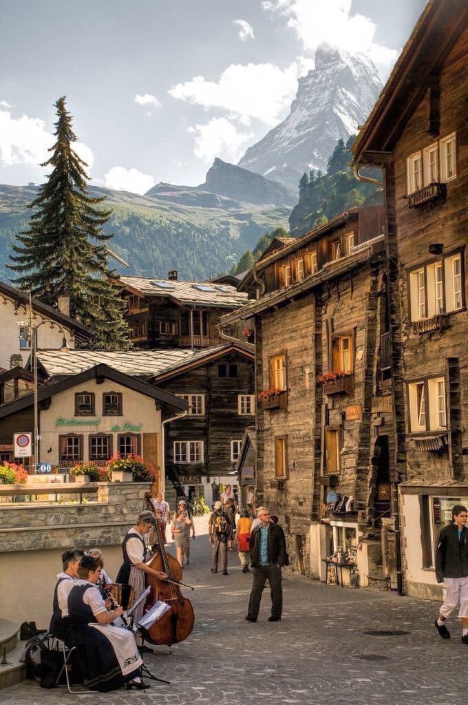 MagicalEurope's tweet photo. Locals playing their instruments with the Matterhorn in the background in Zermatt, #Switzerland https://t.co/3YvtaUQHmF