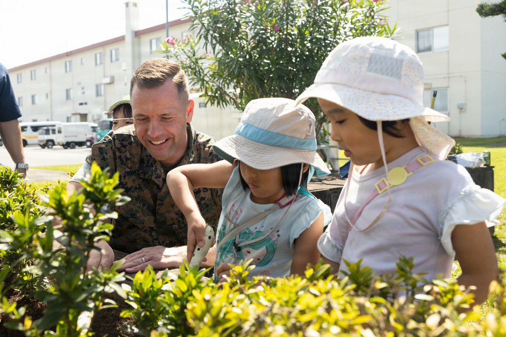 USForcesJapan's tweet photo. U.S. Marines and members of the Uruma Chamber of Commerce &amp; Industry, and local children plant flowers during a Flower Planting ceremony at Camp Courtney, Okinawa 🇯🇵. The flowers, donated by the chamber of commerce, planted help foster the relations between the Marines &amp; locals. https://t.co/dnpZqISPcS