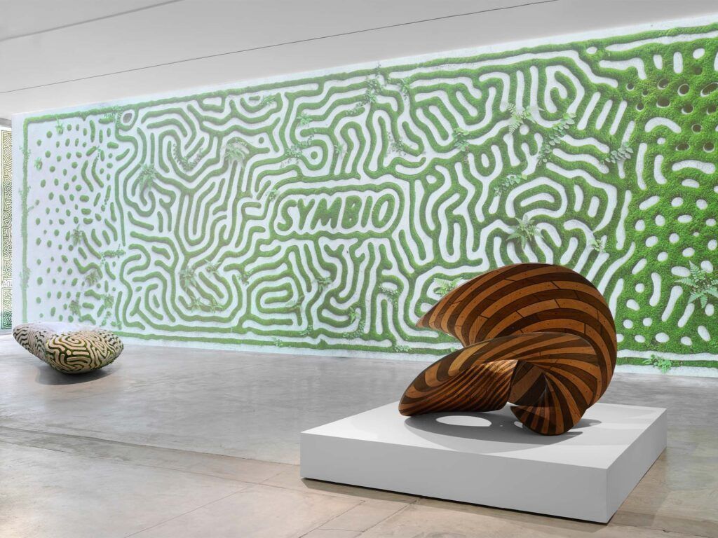 Behold3d's tweet photo. Joris Laarman’s Symbio Benches (2026) at Friedman Benda, NYC — massive 3D-printed recycled/carbon-capturing concrete forms with Turing-inspired reaction-diffusion channels embedded with bio-active substrate for living moss & lichen growth. Boulder-like scale meets symbiotic living textures that evolve over time—pure regenerative sculpture/installation hybrid pushing additive + biology! 🌿🪨✨  

 https://t.co/TZnFU1evS6