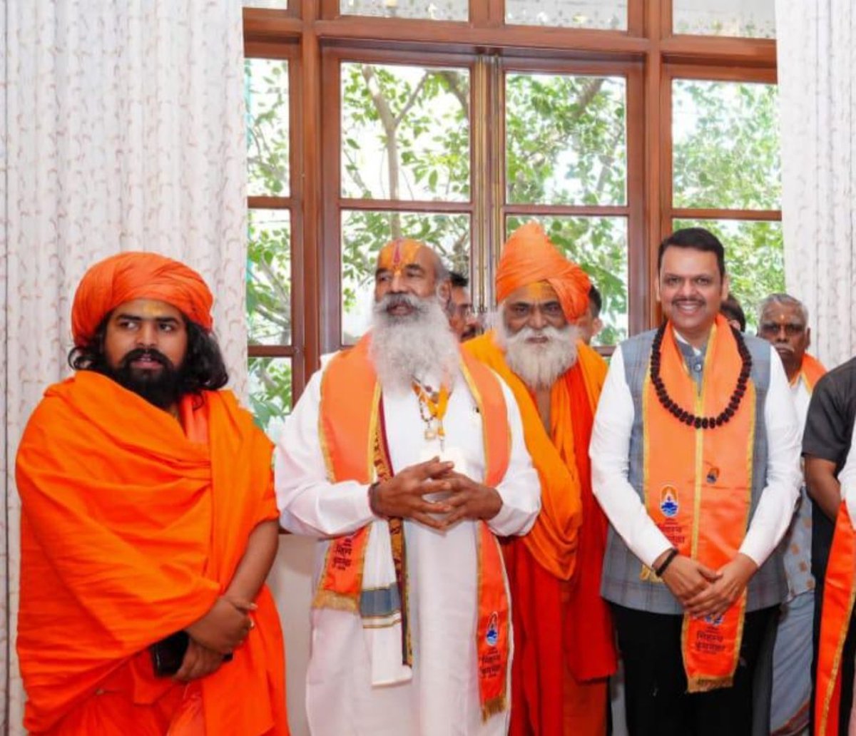 nirgunaady's tweet photo. जूना अखाड़े का वह शौर्य, जो कभी सनातन की ढाल बनकर खड़ा था, आज राजनैतिक फ्रेम की पृष्ठभूमि मात्र बनकर रह गया है जो सलंग्न चित्र इस कड़वे सच का प्रमाण हैं कि जिस सत्ता को कभी संन्यासी मार्ग दिखाया करते थे, आज उसी सत्ता के गलियारों में धर्म-दंड गिरवी रख दिया गया है। आदि शंकराचार्य की वह अजेय नागा परंपरा, जिसने कभी शस्त्र और शास्त्र के बल पर धर्म की रक्षा की, आज सरकारी अनुदानों और 'फोटो-ओप' की मोहताज है। यह वैराग्य का पतन नहीं तो और क्या है कि हिमालय की कंदराओं में तपने वाले तपस्वी अब एयर-कंडीशन और राजनेताओं की चरण वंदना में अपना गौरव ढूंढ रहे हैं। संस्थागत ढांचा इतना भारी हो गया है कि उसकी आत्मा दब चुकी है; अब यहाँ धर्म की रक्षा नहीं, बल्कि पद और प्रतिष्ठा की राजनीति का खेल चल रहा है। यह स्थिति उस संस्थागत ह्रास और मौलिक ऊर्जा के क्षरण का जीवंत उदाहरण है जिसे सुधारने के लिए अब केवल अनुभव आधारित और साहसी विजन ही काम आ सकता है। जब आध्यात्मिक नेतृत्व कुर्सी के सामने झुकने लगे, तो समझ लेना चाहिए कि वह 'अजेय' अखाड़ा अब केवल एक सरकारी विभाग की विस्तार शाखा बनकर रह गया है। यह समझौता उस गरिमा की हत्या है जिसे सदियों के तप से सींचा गया था।