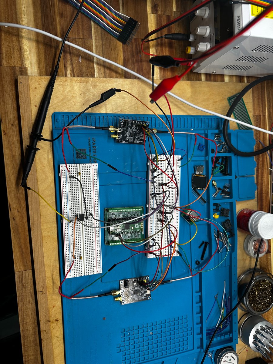 ParallaxPilgrim's tweet photo. Ya, so the preliminary result is that we’ve validated the main Phase 0 hardware chain at the component level.

So far we have confirmed:

The ROJON TCXO is outputting a stable 10 MHz reference clock.
Both ADF4351 RF synthesizer boards can lock using that shared 10 MHz reference.
The Pico can program/enable the ADF boards over the control lines.
The ADF RF outputs are reaching the SA612 mixer.
The SA612 produces a measurable low-frequency IF/beat signal on the oscilloscope when both RF generators are active.

So the basic chain is alive:

10 MHz clock → two RF generators → mixer → measurable IF output.

The main thing I am still validating is controlled dynamic behavior. We have working lock and mixer output, but the first wiring pass was extremely noisy: long jumper wires, breadboard parasitics, loose RF paths, multiple power rails, and long scope/probe leads. Because my oscilloscope experience is still pretty new, I didn’t want to overclaim that the waveform was cleanly proving the intended control behavior yet.

I’ve now rebuilt the setup into a more compact mounted layout with shorter connections and cleaner power/grounding around the mixer. The next test is to confirm that the firmware can independently adjust one ADF oscillator while the other stays fixed, and that the SA612 IF output changes in sync with that firmware state change.

So the current status is:

Component-level Phase 0 chain: validated.

Clean dynamic-control validation: in progress.

Phase 1/next-stage signoff: once we confirm firmware-controlled oscillator changes produce a repeatable, observable change in the mixer IF output.

(image here is what it looked like before i cleaned it up)