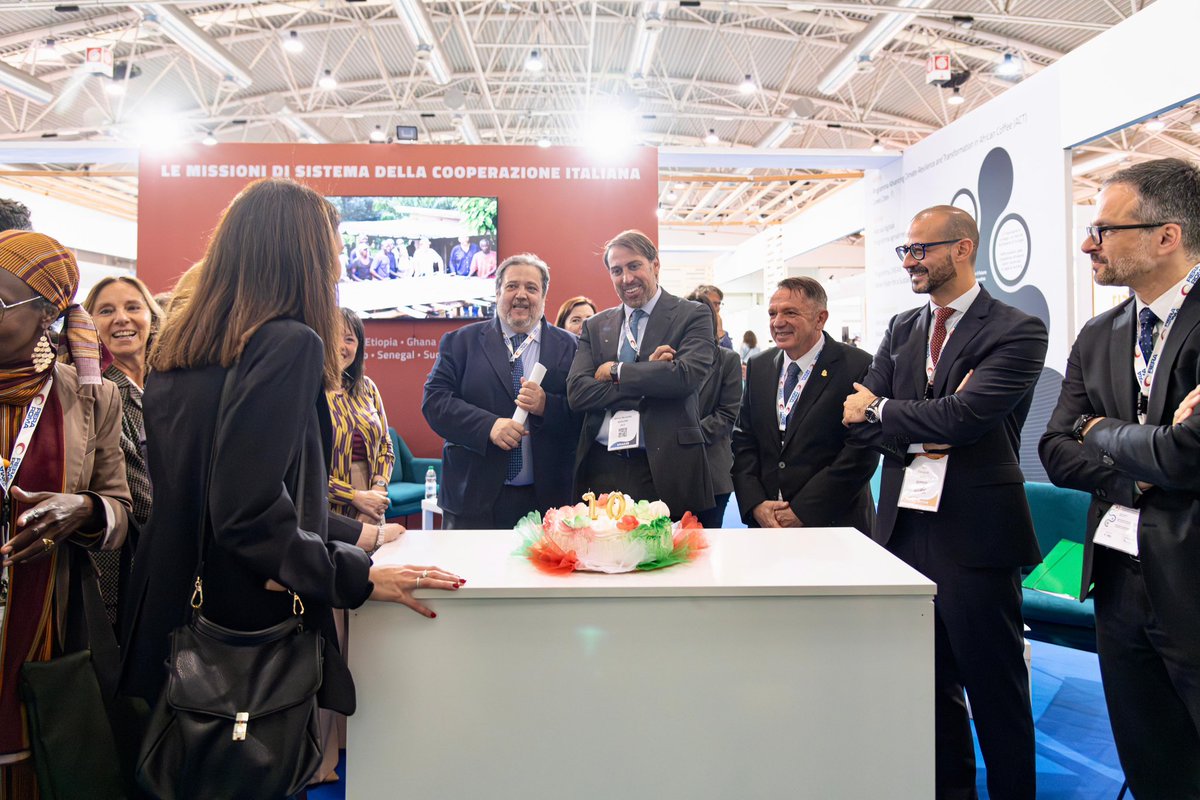 aics_it's tweet photo. A @CodeWayExpo torta a sorpresa per i 10 anni di #AICS 🎂 Tra un panel e l’altro, su iniziativa di Massimo Zaurrini e Fiera di Roma, allo stand della Cooperazione 🇮🇹 abbiamo spento le candeline per il primo decennio di vita dell’Agenzia. Grazie mille e auguri a tutti noi! https://t.co/VGudtCJbcf