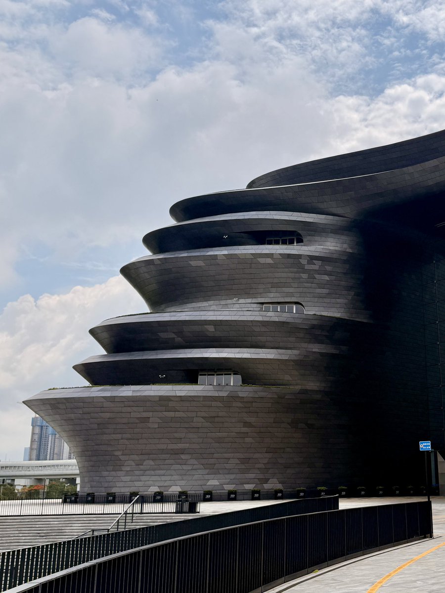 akiramiyoshi's tweet photo. 深圳科学技術館
設計：Zaha Hadid Architects（ZHA）

アルミパネルの割付が美しい。
グレーとブルーそれぞれ4種程度トーン変化。
深圳の光に対して影を鮮明に強調し、
湿度高く淡い空とは見事に呼応する。 https://t.co/r8ZMMqfybJ