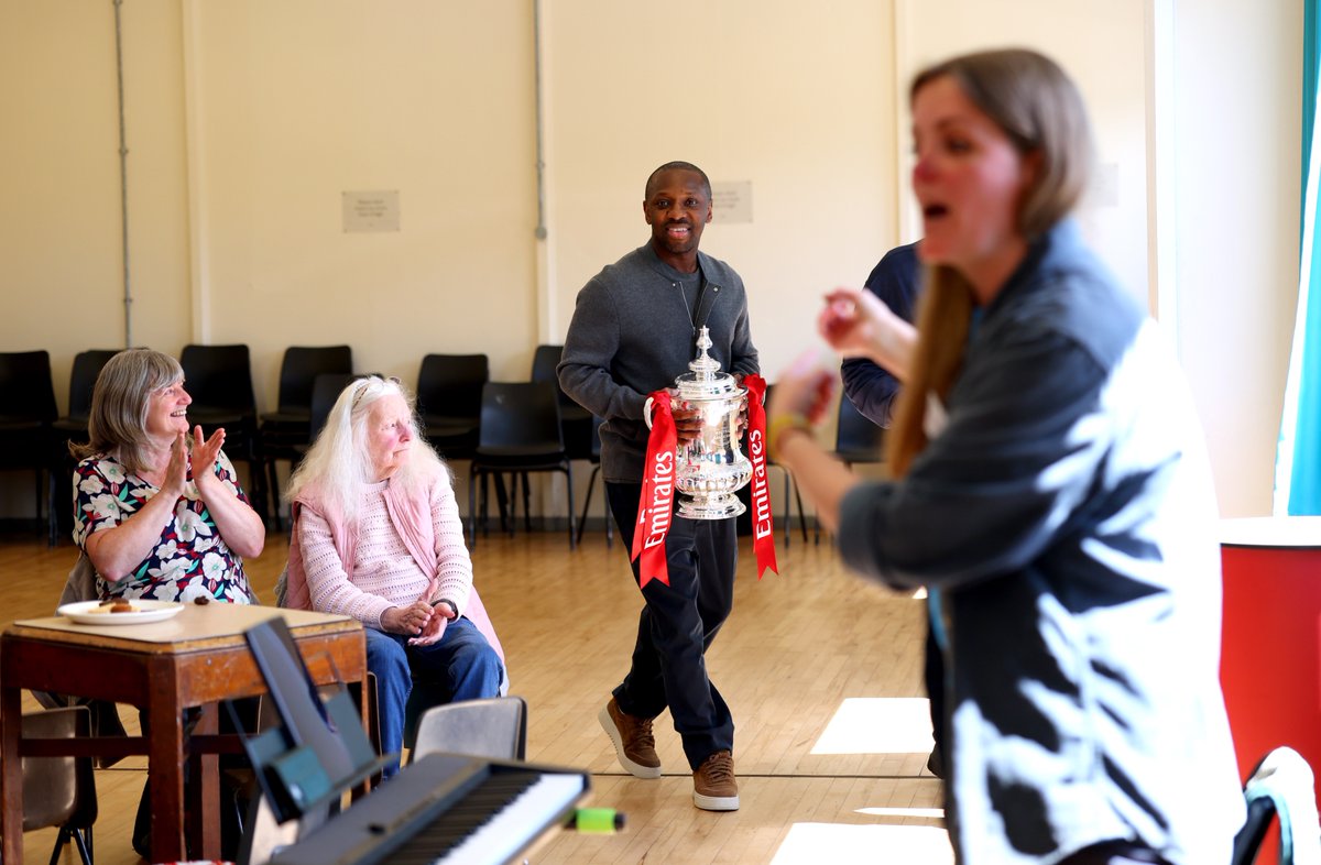 henrywinter's tweet photo. Chelsea icon Paul Canoville takes the FA Cup to an Alzheimer’s Society Dementia Cafe session at the St Vincent's House Day Centre in Hammersmith and Fulham. Shaun Wright-Phillips, who won the Cup with Chelsea and Manchester City, visits an @alzheimerssoc  Singing for the Brain session at the Humphrey Park Community Centre in Manchester. #FACup
