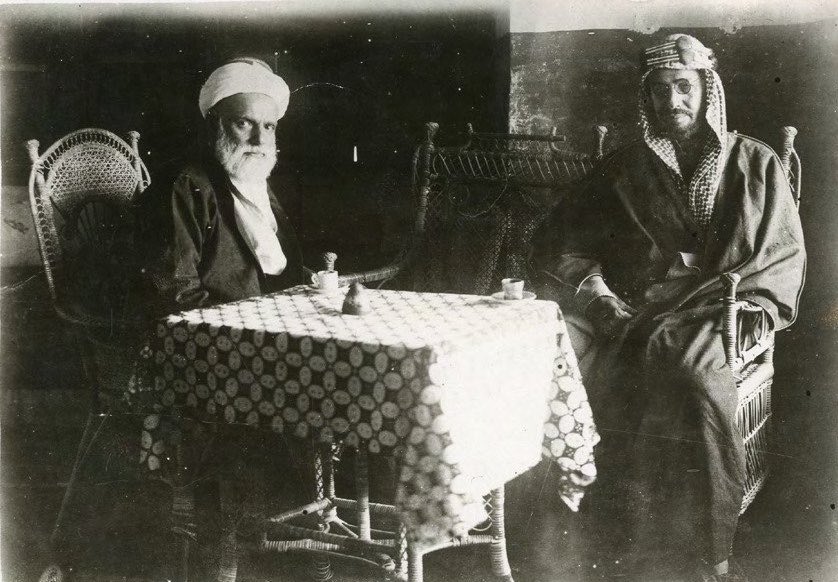 Zainal_Dawlah's tweet photo. "في أوائل ديسمبر 1925، سمعت جدة نبأ استسلام المدينة المنورة للنجديين. فقام معظم كبار أعضاء الحكومة الهاشمية بحزم أمتعتهم واستقلوا السفن إلى مصر. أما الملك علي، فقد أبرق إلى شقيقه الأصغر فيصل، الذي كان البريطانيون قد جعلوه ملكًا على العراق بعد الحرب العالمية الأولى بفترة قصيرة، ورتّب للجوء إليه في بغداد. وفي 20 ديسمبر، صعد بهدوء إلى سفينة بريطانية هي HMS Cornflower. ووفقًا لأفراد من عائلة آل علي رضا اليوم، فإنه كان في الواقع على متن السفينة قبل أن يُعلم الحاج عبدالله — الذي جاء ليودعه الوداع الأخير — بأنه لا يملك أموالًا لرحلته إلى العراق؛ فعرض على الحاكم خنجره الذهبي مقابل بعض المال. وقد رفض الحاج عبدالله العرض بطبيعة الحال — إذ كان من غير المتصوَّر في جزيرة العرب آنذاك (أو حتى اليوم) أن يقبل تاجرٌ أجرًا مباشرًا لقاء خدمة قدّمها لملكه. وبدلًا من أخذ الخنجر، أعطى الحاج عبدالله لعلي 500 جنيه ذهبي (سوفيرن)، وأمر يوسف ومحمد علي في بومباي، حيث كانت HMS Cornflower متجهة، أن يتكفلا بجميع نفقات علي حتى مغادرته إلى العراق.

وحتى قبل حديثه الأخير مع علي على متن السفينة الحربية البريطانية، كان الحاج عبدالله قد بدأ مفاوضاته مع ابن سعود. ففي 17 ديسمبر 1925، كان قد امتطى جواده لمسافة عشرة كيلومترات على الطريق المؤدي إلى مكة، على رأس مجموعة صغيرة من الأعيان، كان من ضمنها الممثل البريطاني في جدة. وبعد ستة أيام من الاجتماعات الصباحية المبكرة، تم الاتفاق على شروط الاستسلام. ومن بين الأمور الأخرى، وافق ابن سعود على إبقاء جميع موظفي الحكومة الهاشمية المدنيين في مناصبهم — غير أن الحاج عبدالله، للحصول على هذا التنازل، اضطر مرة أخرى إلى أن يمد يده إلى خزائنه الشخصية ليقرض الحكومة الجديدة مبلغ 6,000 جنيه إسترليني.

أما الفصل الأخير فكان الاستسلام ذاته. فقد دُعي ابن سعود إلى القدوم إلى جناح أُقيم في حديقة تقع خارج أسوار جدة مباشرة. (وفي هذا الموقع اليوم يقع فندق قصر الكندرة، المعروف لدى رجال الأعمال والصحفيين الزائرين بأنه منشأة باهظة الثمن ذات مستوى متواضع). وهناك جاء كبار أعيان جدة لتحية حاكمهم الجديد وإعلان ولائهم له. وعندما انتهت المراسم البسيطة، سلّم الحاج عبدالله رسميًا مفاتيح المدينة إلى ابن سعود، وقدّم استقالته من منصب الحاكم. إلا أن ابن سعود رفض قبولها. فقد صرّح فورًا وبصراحة بأنه يريد لعبدالله المُنهك أن يبقى في منصبه ليطمئن أهالي جدة ويمنح حياة المدينة استمرارية في ظل الحكومة الجديدة. ولم يكن ذلك طلبًا يُسمح لعبدالله برفضه. وما إن انتهى حديثهما حتى شرب الرجلان فنجانًا من القهوة، والتقطا الصورة الشهيرة للاستسلام، والتي لا تزال معلّقة اليوم في مكتب الشيخ أحمد يوسف زينل علي رضا.

وهناك عنصر رمزي في تلك الصورة يبدو وكأنه تنبأ بطبيعة النظام الذي سيأتي لاحقًا. فمن الواضح تمامًا في الصورة أن كلاً من ملك السعودية المستقبلي والحاج عبدالله كانا يشربان القهوة التركية الحجازية الكثيفة الحلوة، في فناجين قهوة تركية صغيرة، لا القهوة النجدية المُرّة التي تُقدَّم في أوعية صغيرة. وقد تحقق الوعد الضمني الكامن في هذه اللفتة البسيطة. فبعد يومين من الاستسلام، وخلال مجلس (majlis) عُقد في منزل عائلة نصيف، وافق ابن سعود على اقتراح الحاج عبدالله وغيره من كبار الأعيان بأن الحجاز لا ينبغي أن يُضم إلى سلطنة نجد، بل يجب أن يكون جزءًا من دولة جديدة هي مملكة نجد والحجاز. وأصبح ابن سعود يُعرف باسم الملك عبدالعزيز، وبعد سبع سنوات، في عام 1932، تم تغيير اسم الدولة إلى المملكة العربية السعودية."

-مايكل فيلد في كاتبه "التجار: العوائل التجارية الكبيرة بالسعودية ودول الخليج" 1985م.

#تاريخ_الخليج_المعاصر #آل_زينل #بني_هاشم #الذاكرة_الحجازية