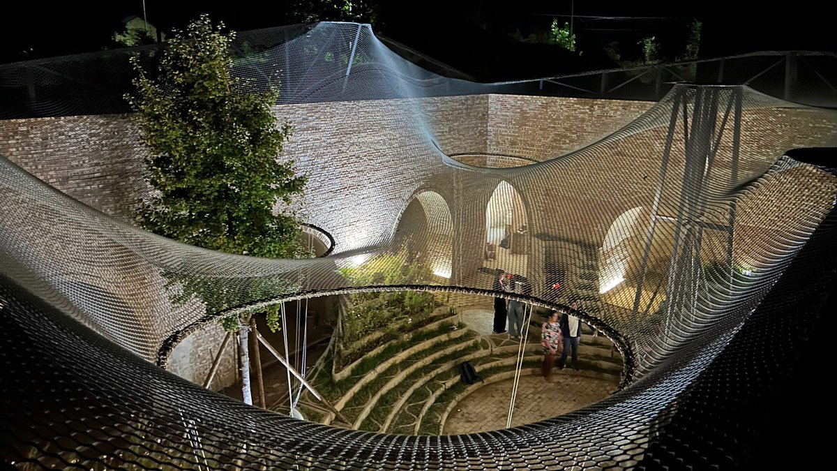 Behold3d's tweet photo. Underground House of the Future by HKU professors John Lin, Olivier Ottevaere & Lidia Ratoi + student team (completed March 2026, northern China). Robotic 3D-printed concrete terraces integrated into a revitalized traditional cave dwelling—multidirectional brick vaults, tensile canopy, earthen thermal mass creating an immersive event-space installation. Raw, textured hybrid of ancient + additive that turns a 6m-deep courtyard into sculptural public art with living functionality. Mind-bending scale & innovation! 🪨🏠✨  
https://t.co/8PhQkQaWIB