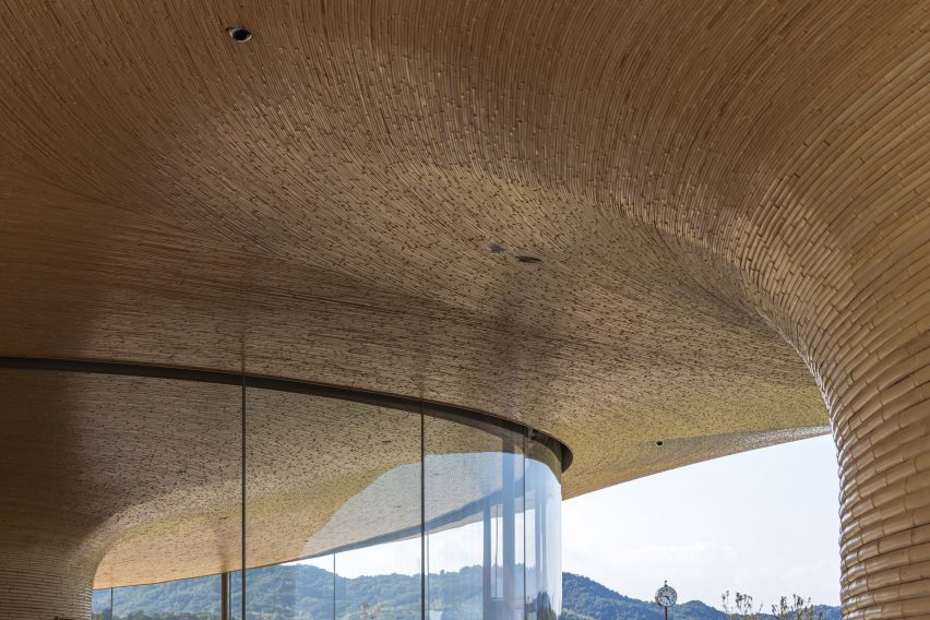 tatamispaces's tweet photo. In 2018, flooding destroyed much of Mabi, a small town in Okayama Prefecture. The reconstruction plan included a disaster-prevention park, and Kengo Kuma and Associates designed the community center anchoring it.

Bamboo Gate is two rectangular volumes separated by an opening that reads as a gateway. A swooping bamboo-clad roof connects them, curving toward the surrounding landscape. Together, the building and the Mabi Reconstruction Disaster Prevention Park form the town's primary resilient public space.

Bamboo, structural and local, for a flood-recovery building. The brief is visible in the material.

📷 Dezeen