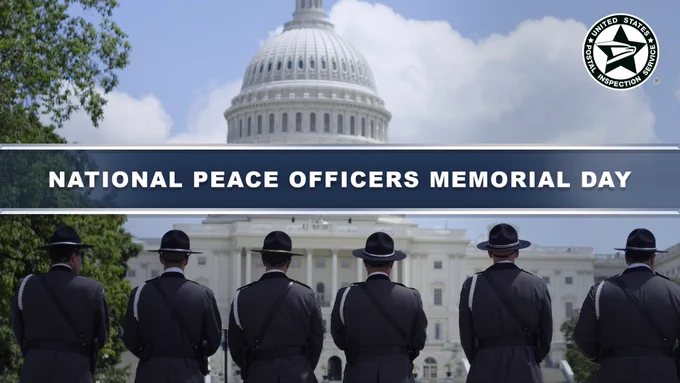 Six uniformed officers stand solemnly facing the U.S. Capital in observance of National Peace Officers Memorial Day.