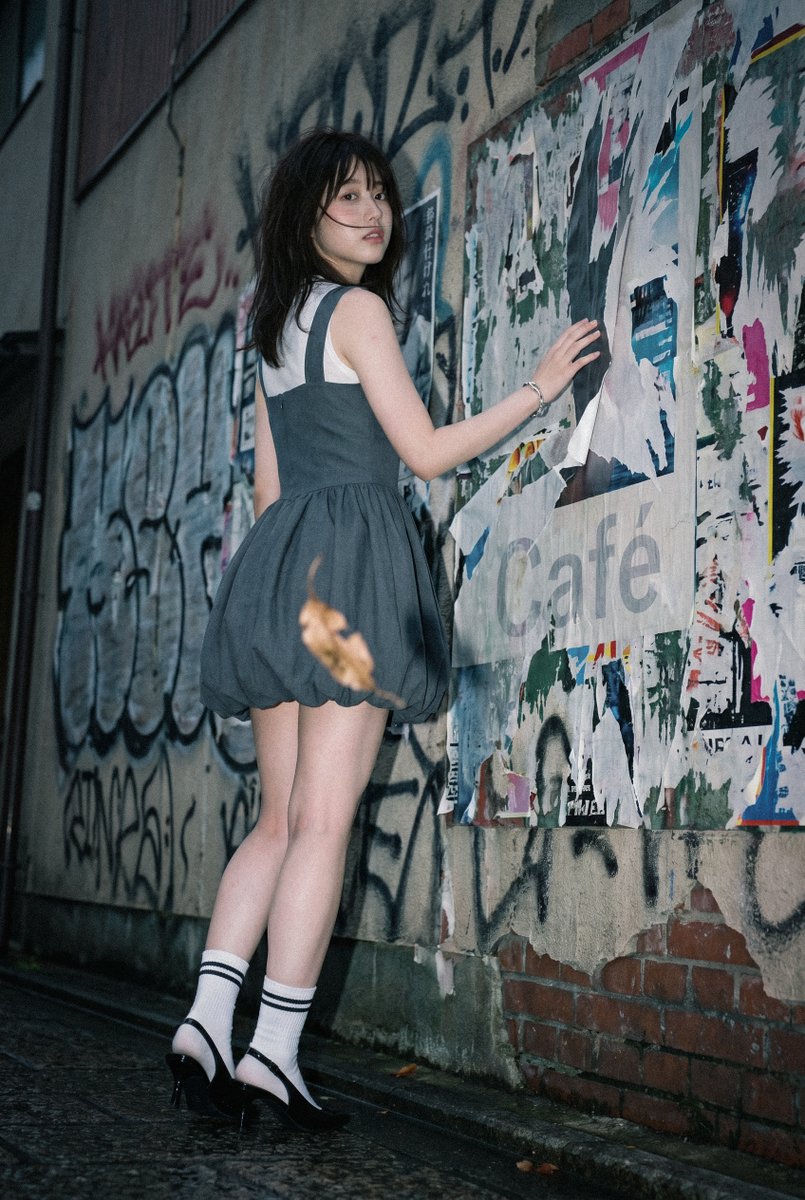 KusoPhoto's tweet photo. テーマ「 #灰色の静寂 」
キーワード：曇り空 / 風に舞う前髪 / 石畳の街

よければこのテーマやキーワードで作ってみてください✨
ファッション のご試着だけでもOKです！

本日の #空想AIファッション：
Charcoal grey sleeveless bubble hem mini dress with a structured straight-cut neckline, layered over a white sheer mock-neck sleeveless top with a thin black horizontal stripe across the chest, fitted bodice cinching at the natural waist transitioning into a voluminous puffed balloon skirt with gathered draping, paired with white ribbed crew socks featuring black stripe trim and small lettering detail, glossy black patent leather pointed-toe kitten heel slingback flats, silver chain-link bracelet on the wrist, minimalist silver rings, clean preppy-meets-modern silhouette