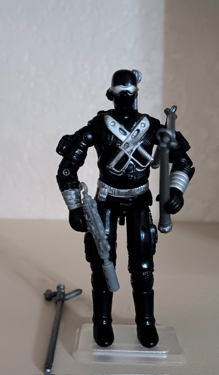 BigRedHead82's tweet photo. From my collection, complete, 1989 Snake Eyes v.3. Snake Eyes came with a black backpack, a silver sword, a gray uzi submachine gun, a set of silver three-piece nunchuks, and a silver blow gun.

This is actually my least favorite version of Snake Eyes. The face mask always looked weird to me, not sure what the pouch or whatever that is on the side of his head is. The two trench knives on his chest are a cool detail, but that alone doesn't really sell the figure for me. His weapons aren't all that great either, I have no memory of ever seeing Snake Eyes use a blow gun in the cartoon or the comics, and the nunchucks or whatever just seem weird to me. It's like Hasbro tried to go back to the commando look while trying to keep the ninja vibe and failed on both accounts. I know this is a look he had in the comicsfor awhile, but the look of Snake Eyes in the comics did not translate well into the figure. 

Overall, it's not a bad figure, Snake Eyes as a character is iconic enough he should be in any Joe collection. This just isn't his best representation from the original 82-94 line of figures. Interesting side note, and maybe someone else (looking at you @gijoeguy84) can tell me the exact current number counting all the recent classified versions of Snake Eyes. But, according to https://t.co/0nlgwhK5JI, from 1982-2014, there have been 68 versions of Snake Eyes produced. I thought that was interesting. 
#GIJoe #GIJoeNation #ARAH #YOJOE #3DJoes #VintageToys #80sToys #actionfigures #GIJoeCollecting #ToyCollecting #toyphotography #OneJoeADay