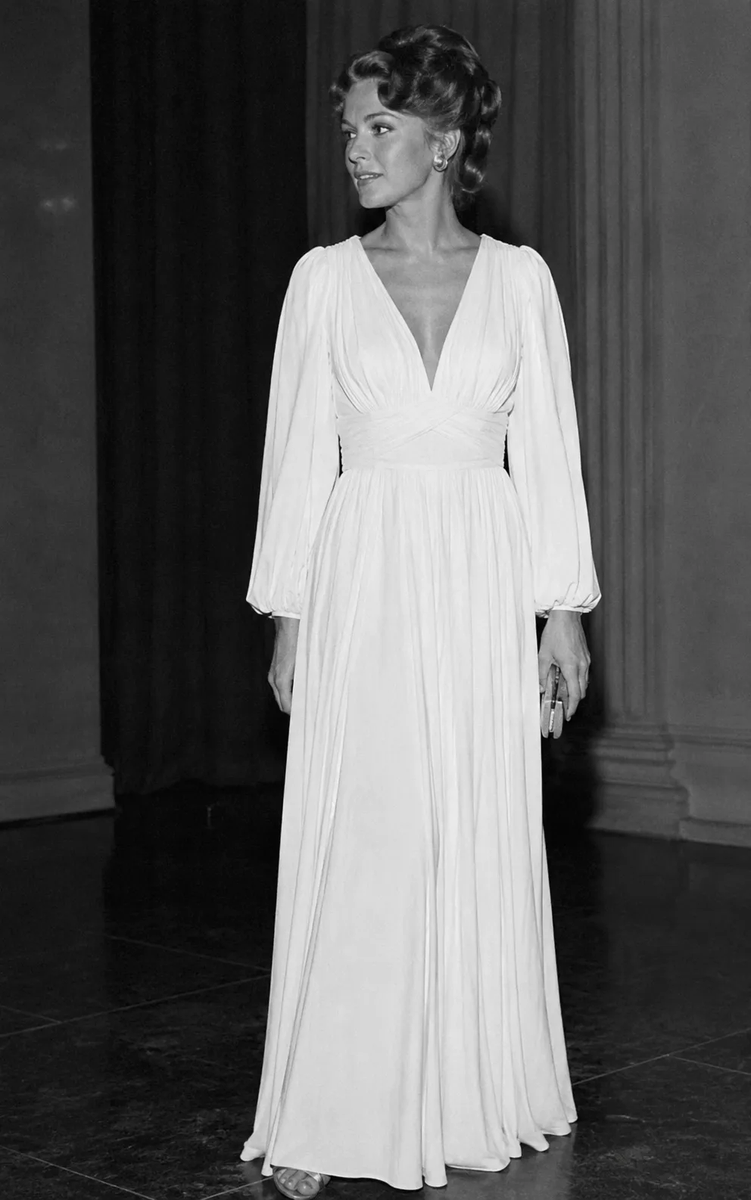 DrReemAlattas's tweet photo. 2️⃣ طلبنا فستان أرشيفي دقيق من عام 1974 (عصر Diana Vreeland والجمال الرومانسي القديم).

• ChatGPT: 

طلع بطل! حول الصورة أبيض وأسود تلقائياً، وعطانا فستان حرير شيفون بفتحة V وأكمام واسعة ملمومة.. كأنه تصميم أصلي من Halston في السبعينات. جاب التاريخ، ووزن القماش، والمود الفني بذكاء مبهر! 🤯