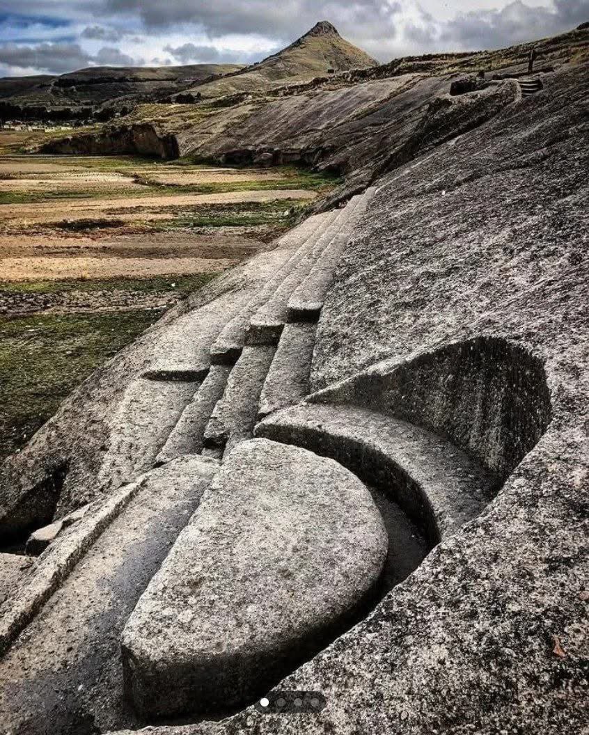 UnearthedHQ's tweet photo. They Carved THIS Into Solid Stone… But Nobody Knows Why

High in the cold mountains near Lake Titicaca lies one of Peru’s strangest and least understood ancient sites — the mysterious megalithic carvings of Quenuani. At first glance, the smooth grooves and giant stone shapes look almost modern, as if massive machines had sliced through the mountain. But these carvings are ancient… and their true purpose is still debated.

The site is believed to date back to the pre-Inca period, possibly over 1,000 years old, though some researchers think parts of it could be even older. It sits in the Andean highlands near Lake Titicaca, a region long connected with ancient legends, lost civilizations, and the origins of the Inca people themselves.

What makes Quenuani so fascinating is the precision of the carving. Huge sections of living rock were cut into smooth channels, stair-like shapes, circular basins, and geometric forms. Some archaeologists believe it may have been an unfinished ceremonial complex or a sacred ritual site connected to water worship — something extremely important in Andean cultures. Others think it may have been used for astronomical observations, sacrifices, or elite ceremonies performed high in the mountains.

And then there are the theories that refuse to disappear.

Some visitors claim the stone looks “machined,” as if advanced tools were used to shape it. The perfectly smooth surfaces and unusual symmetry have fueled endless speculation online. Was it created by a forgotten civilization with engineering knowledge far ahead of its time? Or are we simply underestimating the skill of ancient stoneworkers who spent generations shaping the mountain by hand?

No one knows for certain.

The region around Lake Titicaca has always been wrapped in mystery. According to Inca mythology, the first Inca rulers emerged from these waters after the great creator god Viracocha brought order to the world. Nearby sites like Sillustani and Tiwanaku already challenge what many people think ancient societies were capable of building. Quenuani only deepens that mystery.

Standing before these carvings today feels almost unsettling. The mountain is silent. The stone is scarred with lines and shapes whose meaning has been forgotten. And somewhere in those cuts may lie the remains of a story that history never fully recorded.

Who carved it?
How long did it take?
And what was so important that they reshaped an entire mountainside to create it?

Some ancient places give answers.

Quenuani only gives questions.