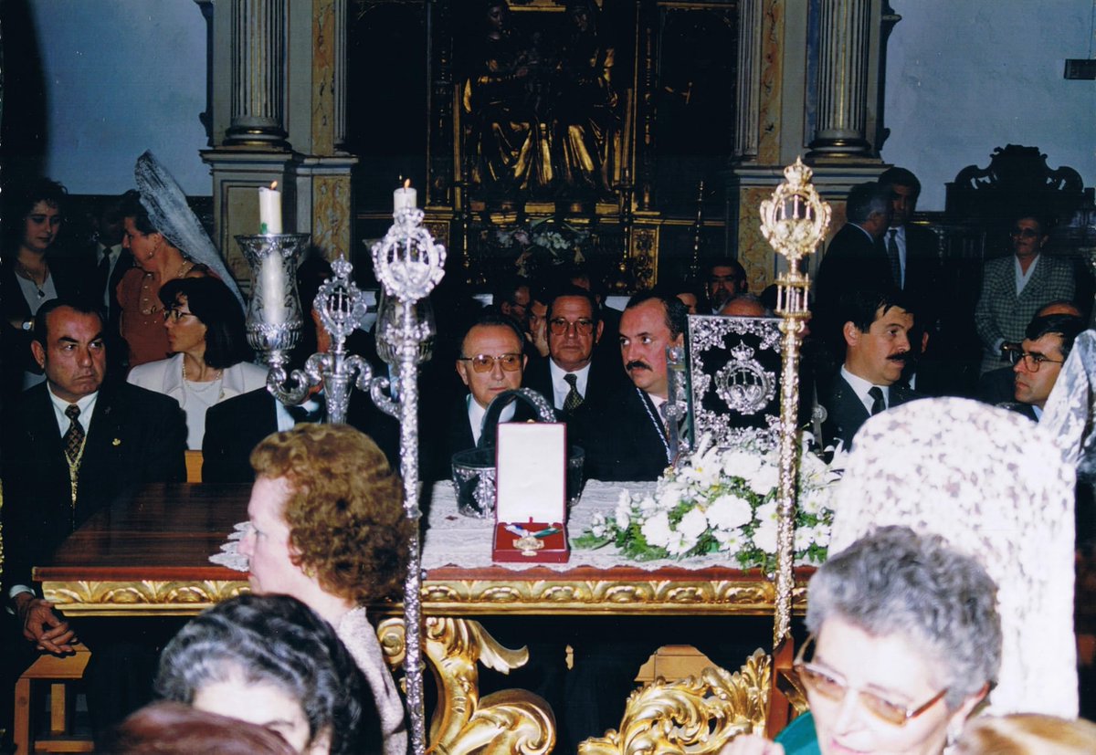 SoyDeLaVeraCruz's tweet photo. [#ACTUALIDAD] | XXX ANIVERSARIO DE LA CONCESIÓN E IMPOSICIÓN DE LA PRIMERA MEDALLA DE ORO DE ALCALÁ DEL RÍO
“Por los méritos contraídos y servicios prestados a esta villa”.

Tras la donación en 1994 al Excmo. Ayuntamiento de Alcalá del Río de un solar, propiedad de la Hermandad en la calle Pimienta de nuestro municipio, para la construcción de un Centro de Salud, le fue solicitada oficialmente, el 4 de agosto de 1995, la Primera Medalla de Oro de la Villa, como reconocimiento a la histórica trayectoria y continua labor de esta Corporación con el pueblo de Alcalá del Río.

Así lo demuestra, además de esta cesión, la ejecución de la que aún hoy sigue siendo la única Residencia de Mayores Virgen de las Angustias, o la inminente construcción del Centro de Día para Mayores Cristo de la Vera-Cruz. Y todas las obras de caridad que esta Hermandad lleva a cabo con el espíritu franciscano de asistencia y espíritu de servicio desde sus orígenes a finales del siglo XV.

En aquel entonces, desde el Ayuntamiento, se dio instrucción a la solicitud efectuada por la Hermandad mediante el Decreto 79/1995, de 25 de septiembre, solicitándose a nuestra corporación un dossier donde se hicieran valer los méritos para obtener la mencionada condecoración. Tras la entrega del dossier, en acuerdo plenario del Ayuntamiento se decidió su aprobación el 10 de enero de 1996: “por los méritos contraídos y servicios prestados a esta villa”.

El acto de entrega de la Medalla se realizó a nuestro Hermano Mayor, D. Antonio Gutiérrez (q. e. p. d.), como representante de la Hermandad, el sábado 18 de mayo, sábado de Quinario, hace hoy treinta años, en la Casa de la Cultura: se otorgaba por riguroso orden de solicitud a las corporaciones solicitantes, siendo, por tanto, la Hermandad de Vera-Cruz la primera en recibirla.

Sería el 19 de mayo, durante la Función Principal de Instituto del Día de la Cruz, cuando se llevaría a cabo la imposición pública de la Primera Medalla de Oro de la Villa, ante el pueblo alcalareño y crucero, junto a los representantes de todas las autoridades y hermandades locales, así como otras invitadas de Sevilla y su provincia.

Para ello, la Virgen Santísima de las Angustias fue entronizada en el mismo lugar en que fuera coronada veinticinco años antes por el cardenal Bueno Monreal (q. e. p. d.), habilitando una escalinata delante del altar para facilitar el acto.

Durante el ofertorio de esta, el Hermano Mayor, junto al señor alcalde, D. Juan Carlos Velasco, ofrendaron la medalla a la Santísima Virgen de las Angustias, siendo impuesta a continuación, tras ser bendecida por nuestro párroco y director espiritual, por su camarera, Dña. Elena Blanca (q. e. p. d.), quien, a modo de madrina, vistió mantilla negra en lugar de la tradicional mantilla blanca de esta festividad, ante el júbilo de los presentes en la iglesia parroquial, que agradeció tan estimada condecoración del Ayuntamiento con una gran ovación.

Traemos a estas líneas las palabras que pronunciara nuestro antiguo Hermano Mayor en la solemne Función de tan marcada efeméride en el seno de nuestro pueblo y sus cofradías: