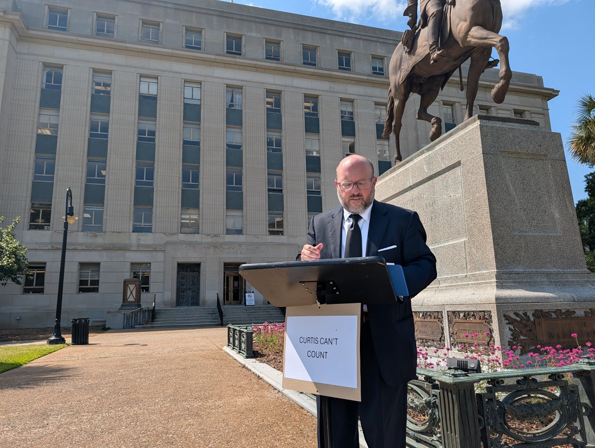 IAmNickReynolds's tweet photo. Democratic candidate for state treasurer (and onetime deputy for former treasurer Grady Patterson) Trav Robertson holding a press conference in front of Republican Curt Loftis' office following the release of an OIG report into his office.

The sign says "Curtis can't count." https://t.co/Xv8R5bEkXh