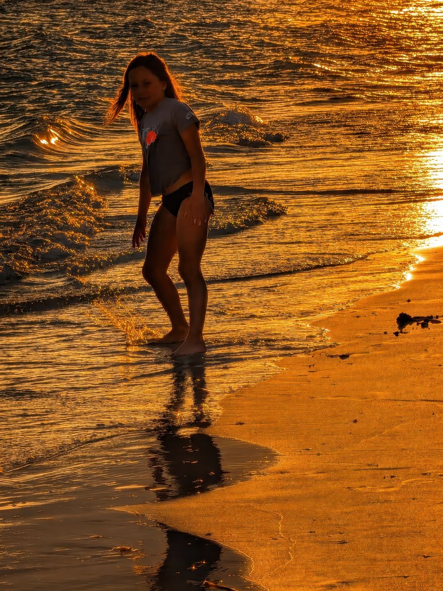 CompuCowBoy's tweet photo. A young girl splashing in the golden surf at sunset. https://t.co/aKZt7Iiwwy