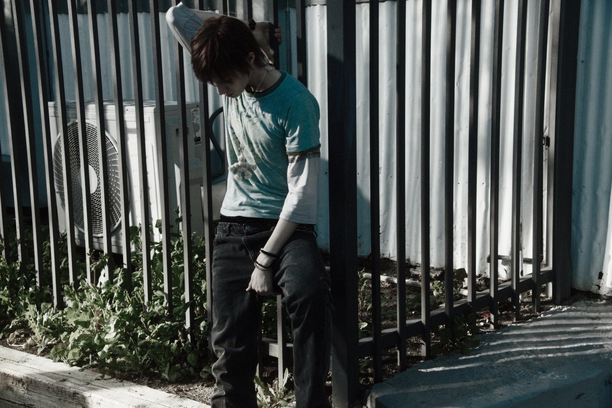 Mvrtin's tweet photo. Sun hitting sideways, head low, hands tucked
away like there’s nothing to explain. 📠 Fence
lines,   worn  denim,   another  slow  afternoon
passing by.  Not hiding, just keeping the world
at  arm’s  length  for  a  while. https://t.co/zv9L8VerBB