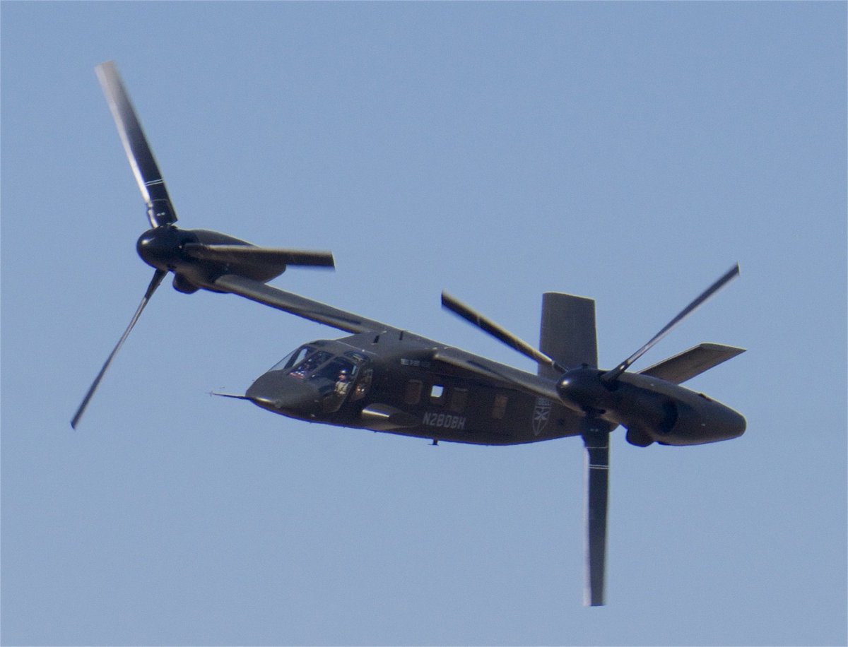 YourOwnRisk9's tweet photo. The MV-75 is significantly smaller and lighter than the MV-22, with a maximum takeoff weight of roughly 31,000 lb compared to 52,600 lb. It has roughly double the combat radius while cruising at similar or slightly higher speeds. The MV-75 has a much wider wingspan of 82 ft versus 46 ft on the MV-22 and markedly lower disk loading, resulting in superior hover efficiency and far less violent downwash. It achieves meaningful weight and complexity savings through its second-generation design with fixed nacelles (only the rotors tilt) and a straight, non-folding wing optimized for land-based operations rather than shipboard compatibility.