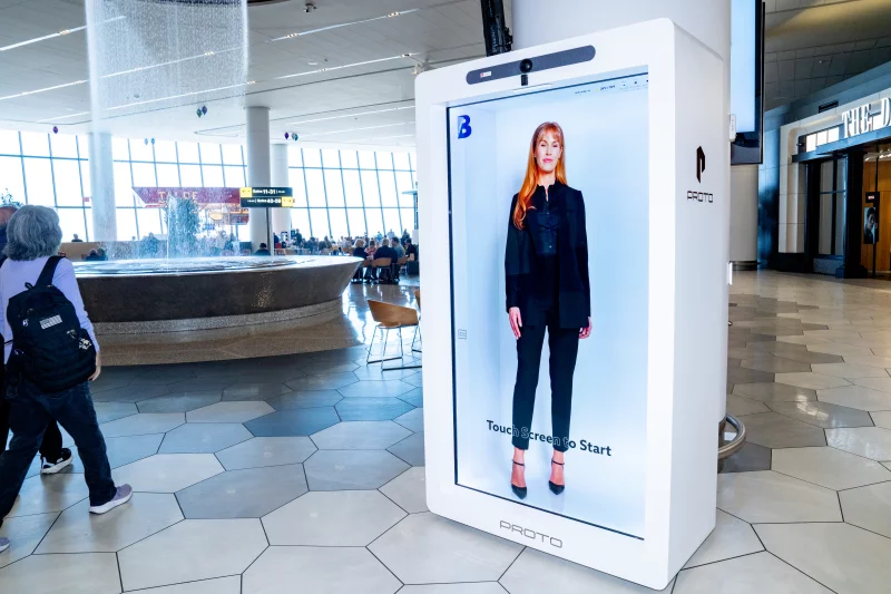 OwenGregorian's tweet photo. AI holograms are reinventing how we navigate airports | Omar Kardoudi, New Atlas

Terminal B at LaGuardia Airport in New York has unveiled Bridget, a life-sized, hyper-realistic AI hologram that can hold a real conversation – answering questions about gates, baggage claims, and VIP lounges. The technology is a signal that the way we navigate airports is changing from static signs and apps to conversational digital guides, and several major hubs are already competing to define it.

Bridget is a collaboration between Proto, the Los Angeles company that had already installed a non‑AI hologram inside JFK’s Terminal 4, and Holomedia's AI Concierge Wayfinder platform. Together they pull real-time terminal maps to deliver step-by-step directions on demand. Bridget currently speaks English and Spanish – more languages are coming – and the kiosk is fully wheelchair-accessible, with on-screen subtitles for good measure. More units are planned across both concourses.

LaGuardia Gateway Partners (LGP), the private company managing Terminal B, frames Bridget not as a replacement for its human staff but as operational backup during peak demand – a digital extension of the guest experience team, with her own character and presence.

"At Terminal B, our North Star has always been to provide an exceptional guest experience through a unique blend of innovation and world-class hospitality," says Suzette Noble, Chief Executive Officer of LGP. "The introduction of the interactive AI hologram aligns perfectly with this vision, allowing us to leverage next-generation technology to meet the evolving needs of our travelers. By providing an additional layer of intelligent, multilingual support, we are ensuring that every guest who passes through our terminal enjoys a seamless and stress-free journey."

LGP has been billing the system as a world first, but that claim deserves a footnote. Miami International Airport had quietly rolled out four conversational AI holographic assistants of its own – developed by Hypervsn, Satisfi Labs, and Mappedin – three weeks earlier.

Miami's system speaks 40 languages compared to Bridget's current two, and it doesn't live only in the building. The same conversational engine powers the airport's website chatbot and WhatsApp assistant, meaning a passenger can start a query at home and pick it up in front of the hologram upon arrival.

What this cluster of deployments really brings to the surface is a deeper question about what we want airports to become, and two very different answers are emerging. One bets on the humanoid avatar, a memorable, personal point of contact. The other bets on ambient intelligence: invisible systems working in the background, from facial recognition boarding gates to multichannel chatbots. It's frictionless by design, though biometric systems at airports have drawn scrutiny from privacy advocates concerned about data retention and consent.

Chinese airports have largely chosen the second path. They’ve been experimenting with holograms since at least 2017, when Guangzhou Baiyun installed holographic safety guidance displays with bilingual explanations of prohibited items. Since then, China’s major hubs have pivoted toward large-scale biometric automation and immersive visual environments. Guangzhou’s Terminal 2 features one of the world’s largest 3D screens, measuring 33 x 25 m (108 x 82 ft), used for glasses-free 3D visuals. It's airport design as a spectacle – passengers have an experience, but not a conversation.

"As passenger expectations evolve, airports are increasingly seeking technologies that not only improve operational efficiency but also create memorable, frictionless, and personalized journeys," says Glenn E. Smith, Spatial Computing XP Architect at Holomedia. Whether either approach will meaningfully reduce the stress of flying remains to be seen. Would you rather interact with human staff, life-size holograms or smart systems when navigating terminals? Let us know in the comments.

https://t.co/i0TS7kd3vD