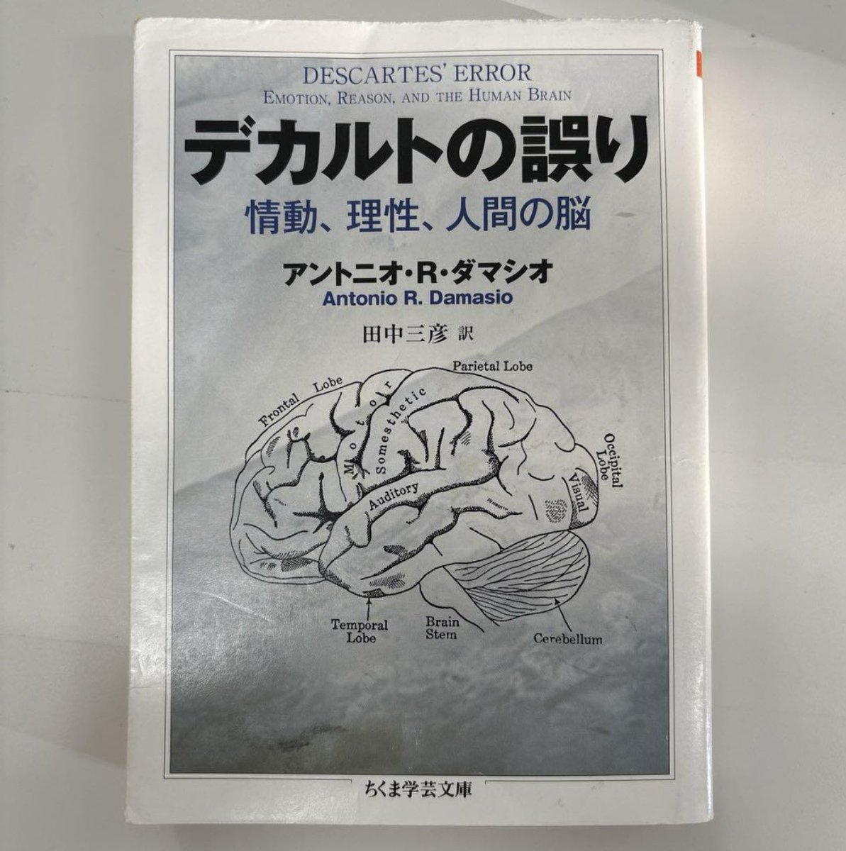 nobushiromasaki's tweet photo. 「冷静で理性的な判断を下すこと」が最善だと考えられている。実は、そんなものは大してアテにならない。むしろ人は感情を基盤にせずに判断を下すことが原理的にできない。意思決定においては感情や理性が複雑に絡み合うが、多くは直感に依存する──ならば、判断をマトモ化するのに何が必要なのか？👉

そのヒントが本書に示されている。

エリオットと呼ばれる脳腫瘍手術を受けた30代男性。彼は術後、理性的な推理能力が損なわれていないにも関わらず、生活上の意思決定になぜか大きな困難をきたし、家庭やキャリアにおける成功を台無しにしてしまっていた。

脳神経学者ダマシオは、そんなエリオットに対し、神経心理学的なテストを行った。知能指数をはじめ、その結果はいずれも正常。というより、非常に優秀だった。にもかかわらず、彼はなぜか意思決定ができない人間になっていた。ダマシオは当初、困惑した。

ところが、謎は解けていく。

ダマシオは、エリオットの「ある傾向」に気づく。それは、極端な感性や情動の減退である。

エリオットはしばしば、第三者のような態度で自分の悲惨な境遇を語った。また、悲惨な事故や災害の写真を見ても感情的な反応がほとんどなかった。あるいは、脳腫瘍の手術前まで愛好していた音楽や絵画について、術後には何の感情もわき上がらなくなったと彼は述べた。

これを受け、ダマシオは、彼に似た患者──脳の前頭前野を損傷した12人について研究を重ねた。すると、全てのケースにおいて「極端な情動の減退と意思決定障害」が等しく起きていることがわかった。

この発見をもとに考察を重ねたダマシオは、やがてソマティック・マーカー仮説を提唱する。以下、概要を引用しよう。

「あなたが、前提に対する費用便益分析のようなものを適用する前に、そして問題解決に向けて推論を始める前に、あるきわめて重要なことが起こる。たとえば、特定の反応オプションとの関連で悪い結果が頭に浮かぶと、いかにかすかであれ、あなたはある不快な『直観的感情』を経験する。その感情は身体に関するものなので、私はこの現象に〈ソマティック〉（ソマ、すなわちsomaはギリシア語で「身体」を意味する）という専門語を付した。そしてその感情は一つのイメージをマークするので、私はそれを〈マーカー〉と呼んだ」（『デカルトの誤り』271頁）

この仮説によれば、人間の意思決定は以下のようなプロセスをたどることになる。

まずぼくらは、状況に内包されている無限ともいえるオプションの中から、ソマティック・マーカーによっていくつかの「あり得ないオプション」を排除する。で、次に、残ったオプションを材料にして、論理的・理性的な推論と思考を重ねる。そして、最終案を絞り込んでいく、と。

ソマティック・マーカーとは、ざっくり言えば、情報に接した時に呼び起こされる感情や身体的反応（汗がでる、心臓がドキドキする、口が渇く等）が、脳の前頭葉腹内側部に影響を与えることで、目の前の情報についての「良い」あるいは「悪い」を判断し、意思決定する営みを効率化する機能を持つ。つまり、直感でざっくり「あり得ない要素」を捨てて、思考をシンプルにする作用がそのマーカーにあるのだ。

ダマシオによれば、エリオットを始めとした前頭前野に損傷を負った人々にはこれが欠けていた。そのため、いつまで経ってもバッサリとオプションを絞り込むことができず、意思決定もできなくなってしまったというのが彼の仮説である。この仮説にしたがえば、これまで言われてきた「意思決定はなるべく感情を排して理性的に行うべきだ」というセオリーは誤りで、意思決定においてはむしろ感情を積極的に取り入れるべきだという話になる（もちろん、この仮説には多くの反論もあり、現時点でこれはあくまでも仮説である）。

ソマティック・マーカーは、コントロールできるものというより、自然と「わく」「機能してしまう」ものである。そのため、ぼくらがそれをどれだけ精密にキャッチできるか、が人生の質を左右する。その際に大事になるのは？

ぼく的に受け取った本書の示唆から導出すれば、そのヒントは、たとえば「比喩」にある。

ぼくらは「現実」をそのまま言語化することはできない。言語にした瞬間、現実にあった豊かさはボロボロと落ちていく。言葉が現実を単純化してしまう。すなわち、現実と言語表現には断絶があるのだ。実は、そんな両者を架橋する飛躍台がある。それが、比喩、メタファーだ。ある現実や現象から特定の構造を抜き出し、似た構造を持つ別のものと結びつけて比喩的に架橋してそれらを語る。この作業がうまくできる人は、意思決定の正確性を増すかもしれない。個人的には、このように複雑なことをわかりやすく語れる人が頭のいい人だと思う。

『デカルトの誤り』
著者：アントニオ・ダマシオ
発行：筑摩書房